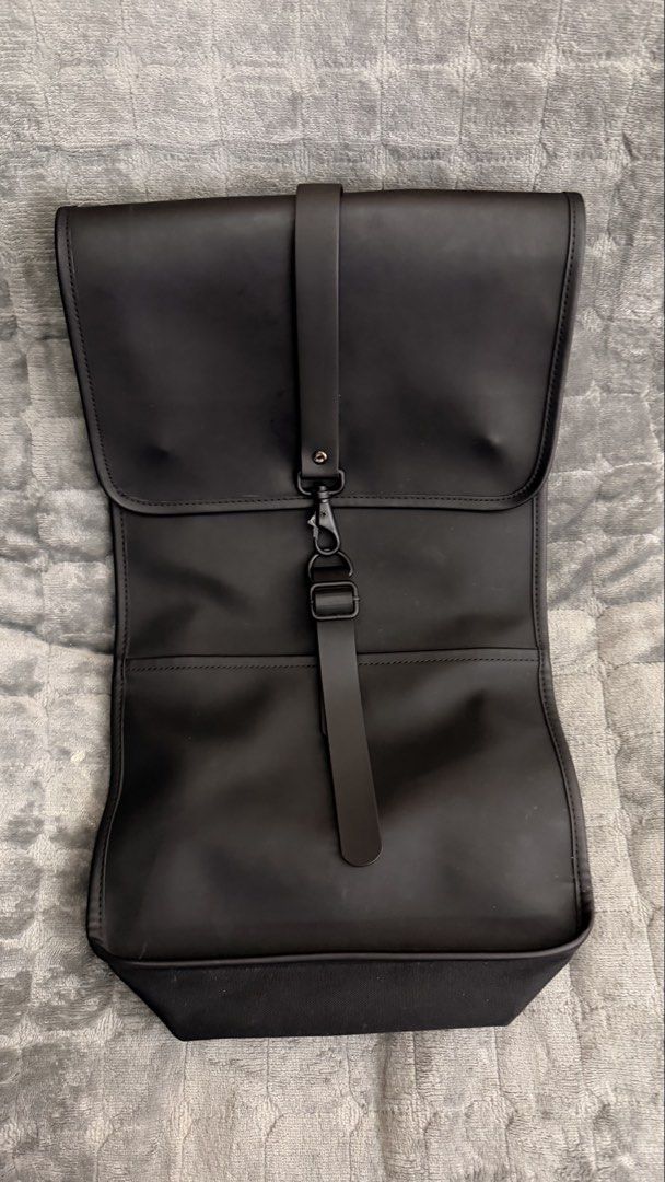 Rains Backpack (Category: Backpacks) located in Alfonso. Submitted by jbcamet (Listing ID 1423818653, Image 3). Description: - Black Rains backpack - Main compartment with zipper - Interior pocket - Front flap with strap closure - Adjustable shoulder straps - Waterproof design - Rains logo inside.