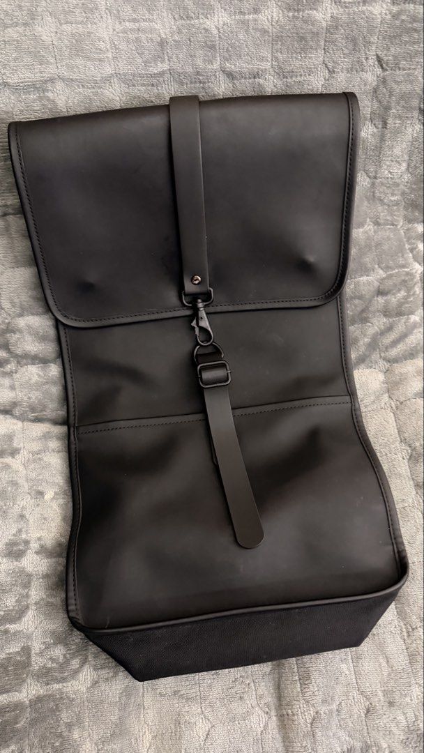 Rains Backpack (Category: Backpacks) located in Alfonso. Submitted by jbcamet (Listing ID 1423818653, Image 1). Description: - Black Rains backpack - Main compartment with zipper - Interior pocket - Front flap with strap closure - Adjustable shoulder straps - Waterproof design - Rains logo inside.