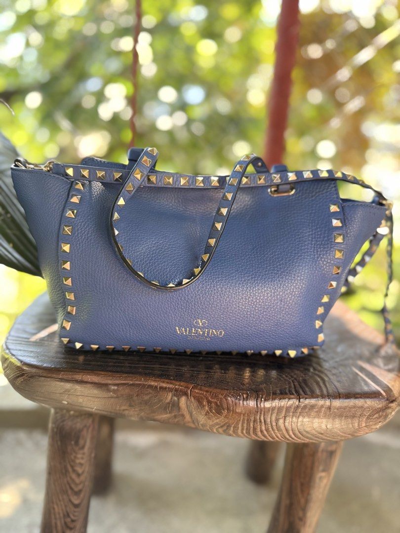 Valentino Garavani Rockstud Tote Bag (Category: Luxury Bags & Wallets) located in Manila. Submitted by fivethousandlilies (Listing ID 1423969070, Image 3). Description: - Valentino Garavani Rockstud tote bag - Gorgeous blue color - Gold-tone hardware - Iconic studded design - Top handle and detachable shoulder strap - Interior zippered pocket - Valentino Garavani logo visible - Made in Italy.