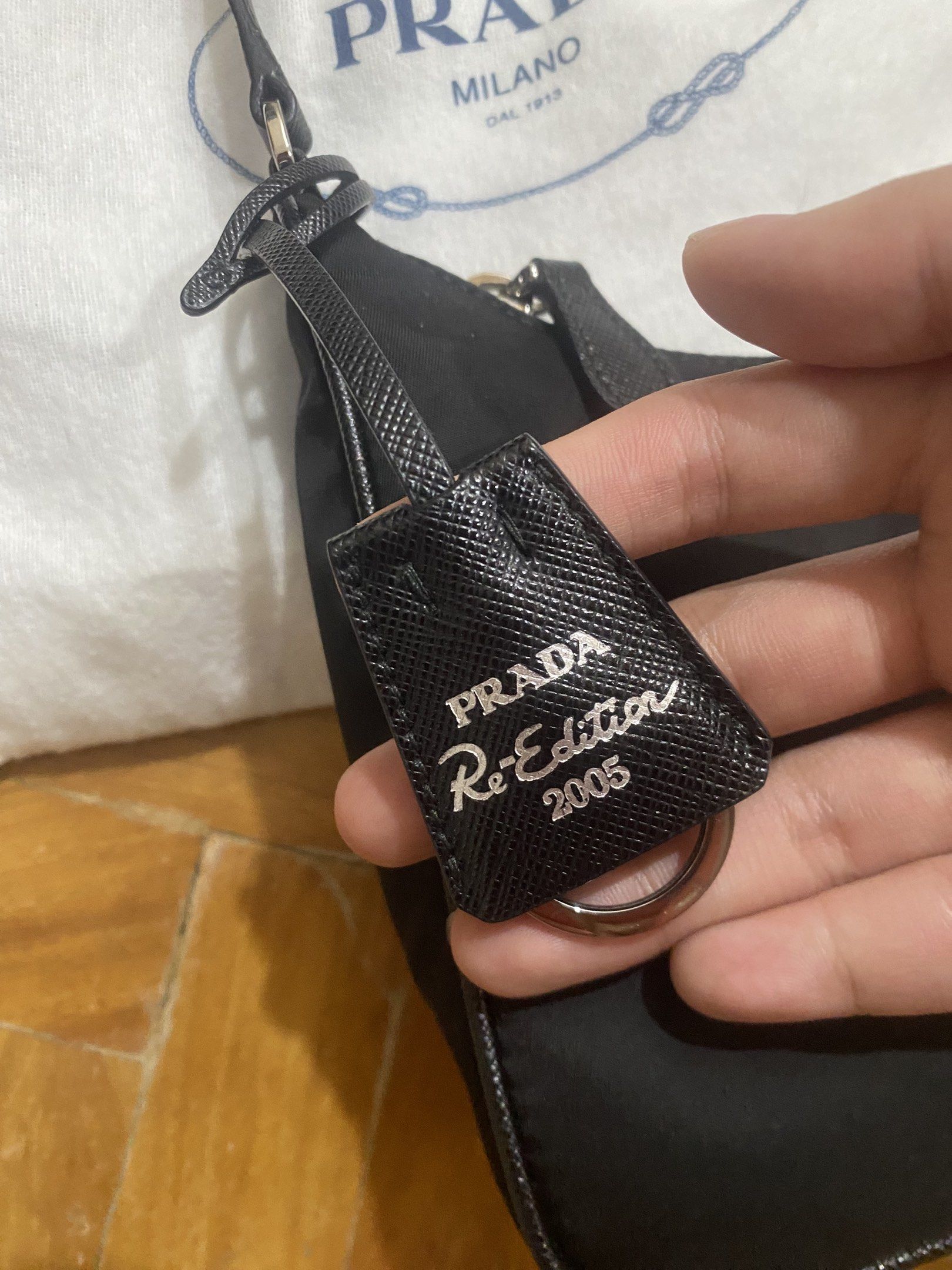 Authentic Prada Re-Edition 2005 Shoulder Bag (Category: Luxury Bags & Wallets) located in Paranaque City. Submitted by juju_closet (Listing ID 1419448997, Image 2). Description: - Authentic Prada Re-Edition 2005 shoulder bag bought from Italy - Black nylon exterior, Silver-tone hardware, clochette is intact, comes with original dust bag. (10/10 condition!) Pm for inquiries 🩷.