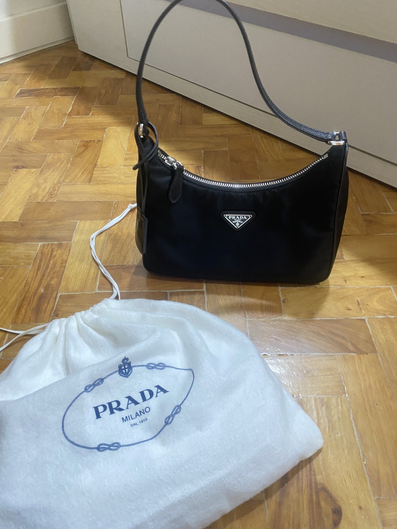 Authentic Prada Re-Edition 2005 Shoulder Bag (Category: Luxury Bags & Wallets) located in Paranaque City. Submitted by juju_closet (Listing ID 1419448997, Image 1). Description: - Authentic Prada Re-Edition 2005 shoulder bag bought from Italy - Black nylon exterior, Silver-tone hardware, clochette is intact, comes with original dust bag. (10/10 condition!) Pm for inquiries 🩷.