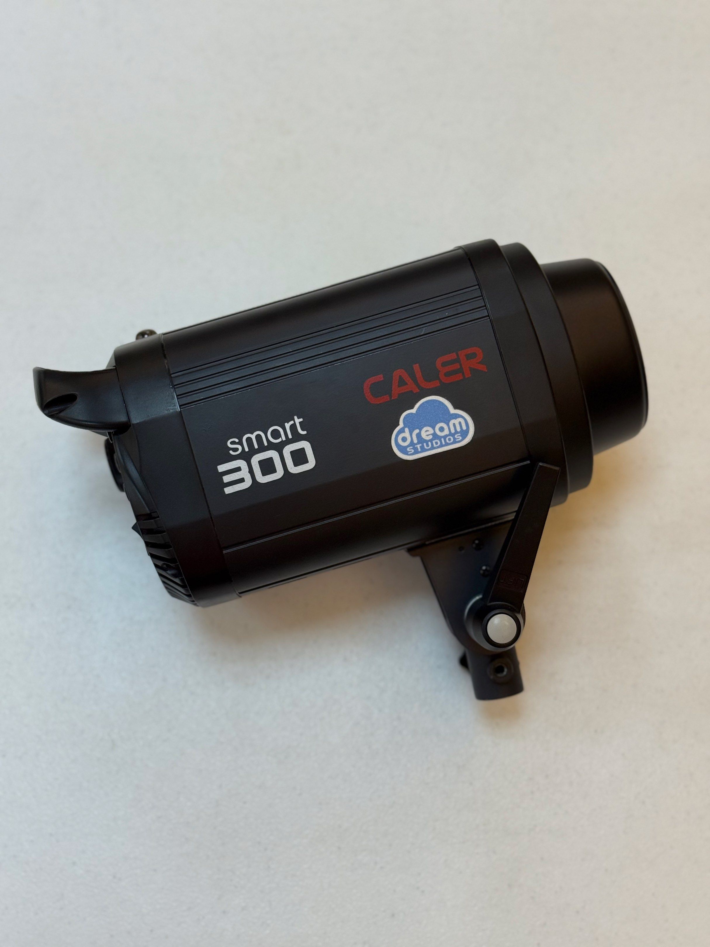 CALER Smart 300 Studio Flash (Set of 3) (Category: Lighting & Studio Equipment) located in Taguig. Submitted by dreamstudios (Listing ID 1419533375, Image 2). Description: Set of 3 - CALER Smart 300W studio flash. Lightly used. Includes all power cords, modeling lamps and covers Features adjustable power settings, a modeling lamp, and a sync port. Includes a protective cover for the flash head. The back panel shows power settings and a USB port. 