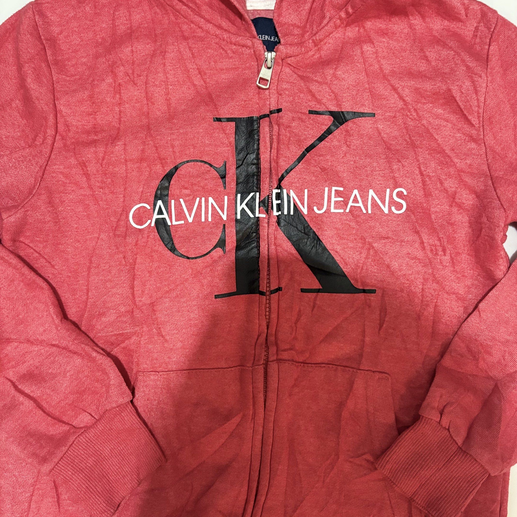 Calvin Klein Jeans Hoodie (Category: Coats, Jackets and Outerwear) located in Imus. Submitted by vinsthrift1997 (Listing ID 1419435508, Image 2). Description: - Red Calvin Klein Jeans hoodie - Size: M (fits 10/12) - Features the Calvin Klein Jeans logo - Zip-up front - Hooded - Long sleeves - Made in Pakistan.