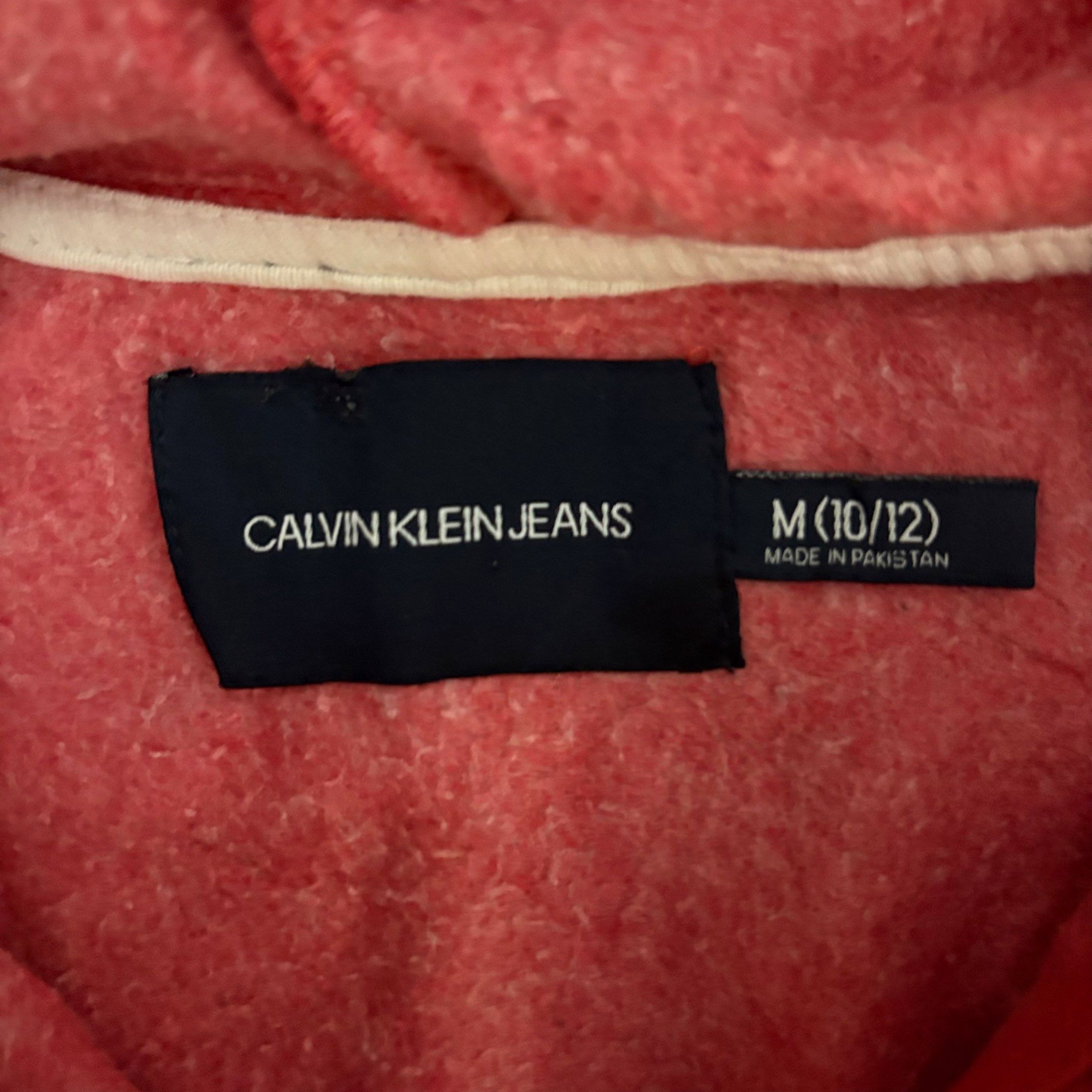Calvin Klein Jeans Hoodie (Category: Coats, Jackets and Outerwear) located in Imus. Submitted by vinsthrift1997 (Listing ID 1419435508, Image 3). Description: - Red Calvin Klein Jeans hoodie - Size: M (fits 10/12) - Features the Calvin Klein Jeans logo - Zip-up front - Hooded - Long sleeves - Made in Pakistan.