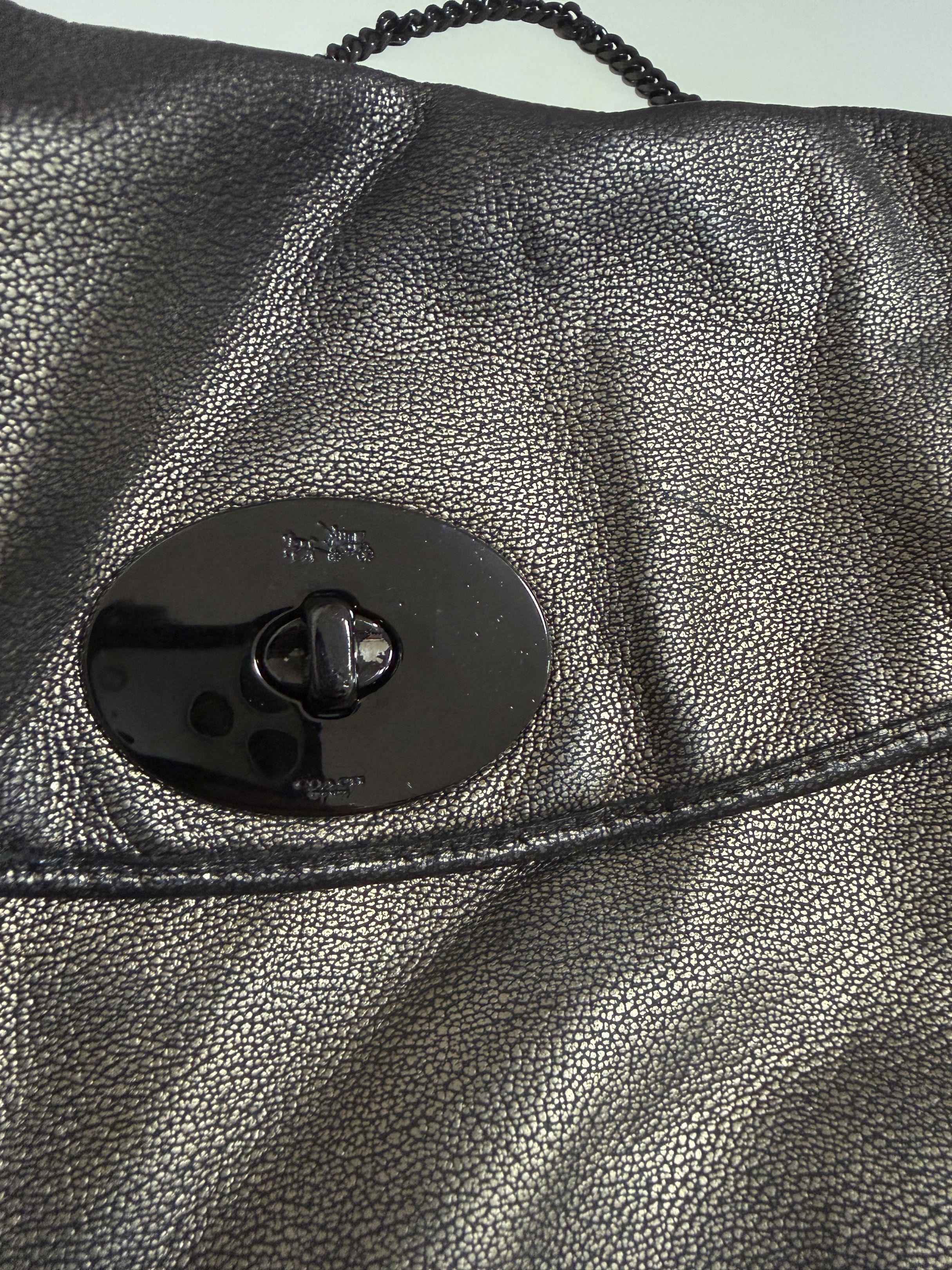 Coach Metallic Shoulder Bag (Category: Luxury Bags & Wallets) located in Mandaluyong City. Submitted by gee028 (Listing ID 1419486604, Image 2). Description: - Coach shoulder bag with metallic finish - Unique clasp closure - Chain strap - Interior zippered pocket - Includes Coach label - Sleek design for various occasions - Made with high-quality materials.