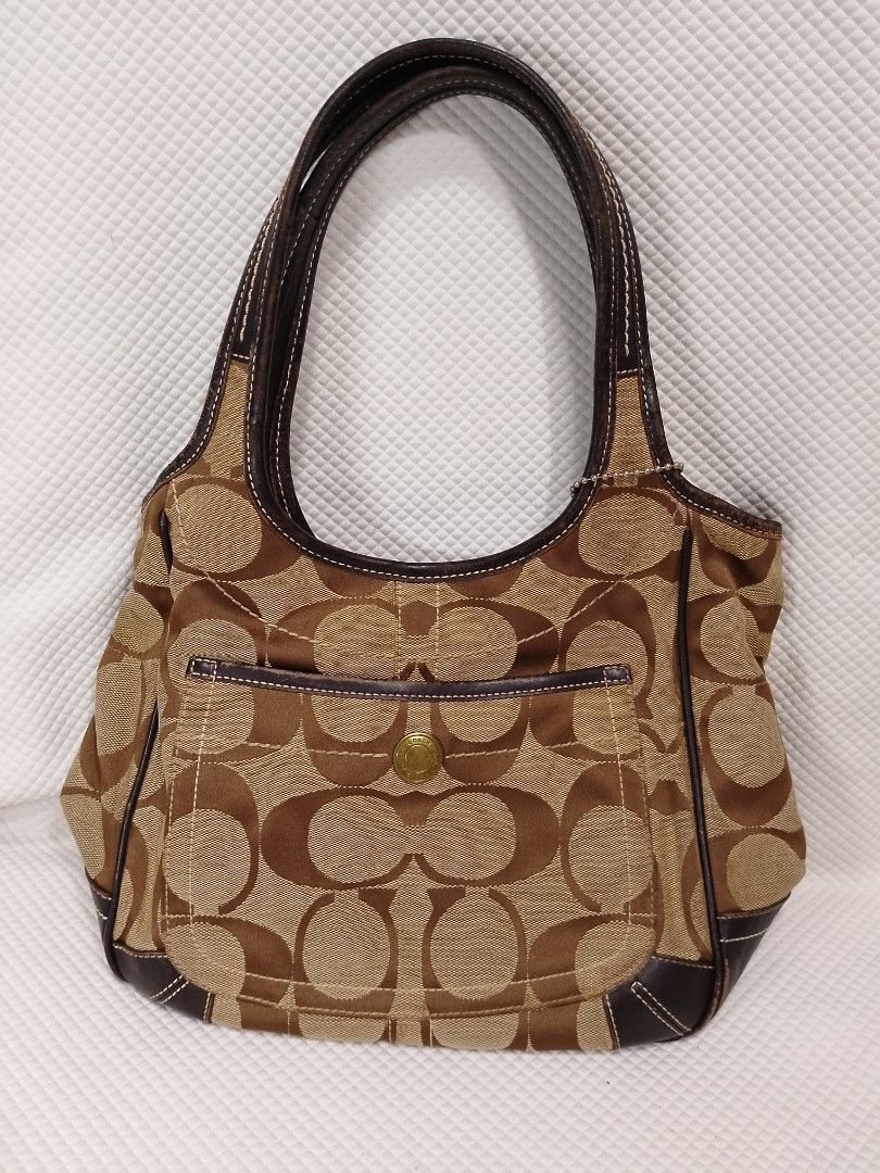 Coach Signature Tote Bag (Category: Luxury Bags & Wallets) located in Manila. Submitted by decorasyon (Listing ID 1419411587, Image 1). Description: - Authentic Coach tote bag - Signature brown and tan design - Front pocket with snap closure - Leather trim - Interior zip pocket - Coach label with model number M0668-10766 - Double handles - Includes Coach hangtag - Shows wear on handles and corners.