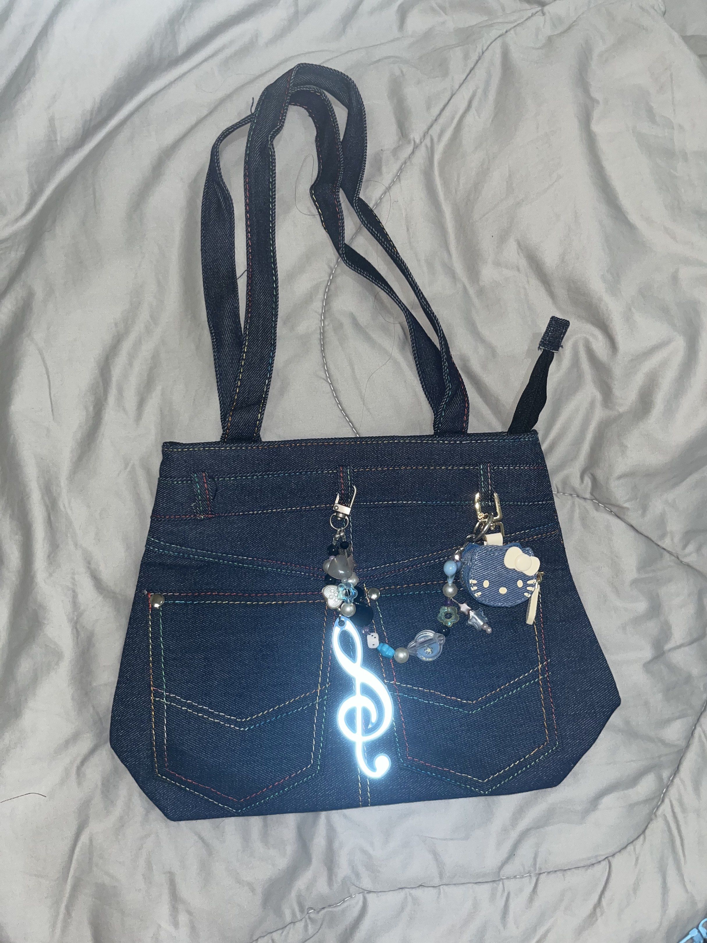 Denim Tote Bag with Charms (Category: Tote Bags) located in Makati City. Submitted by hellogaragekitty (Listing ID 1419572789, Image 1). Description: RARE HK JEANS BAG (wt anik anik) 🦋🩵✨ Reminders! ~ this item is handmade with mix of new and recycled products (specifically beads and trinkets) please set expectations accordingly 🧚🏼‍♀️ ~ color and material might differ on actual due to lighting and etc., rest assured what you see on the picture