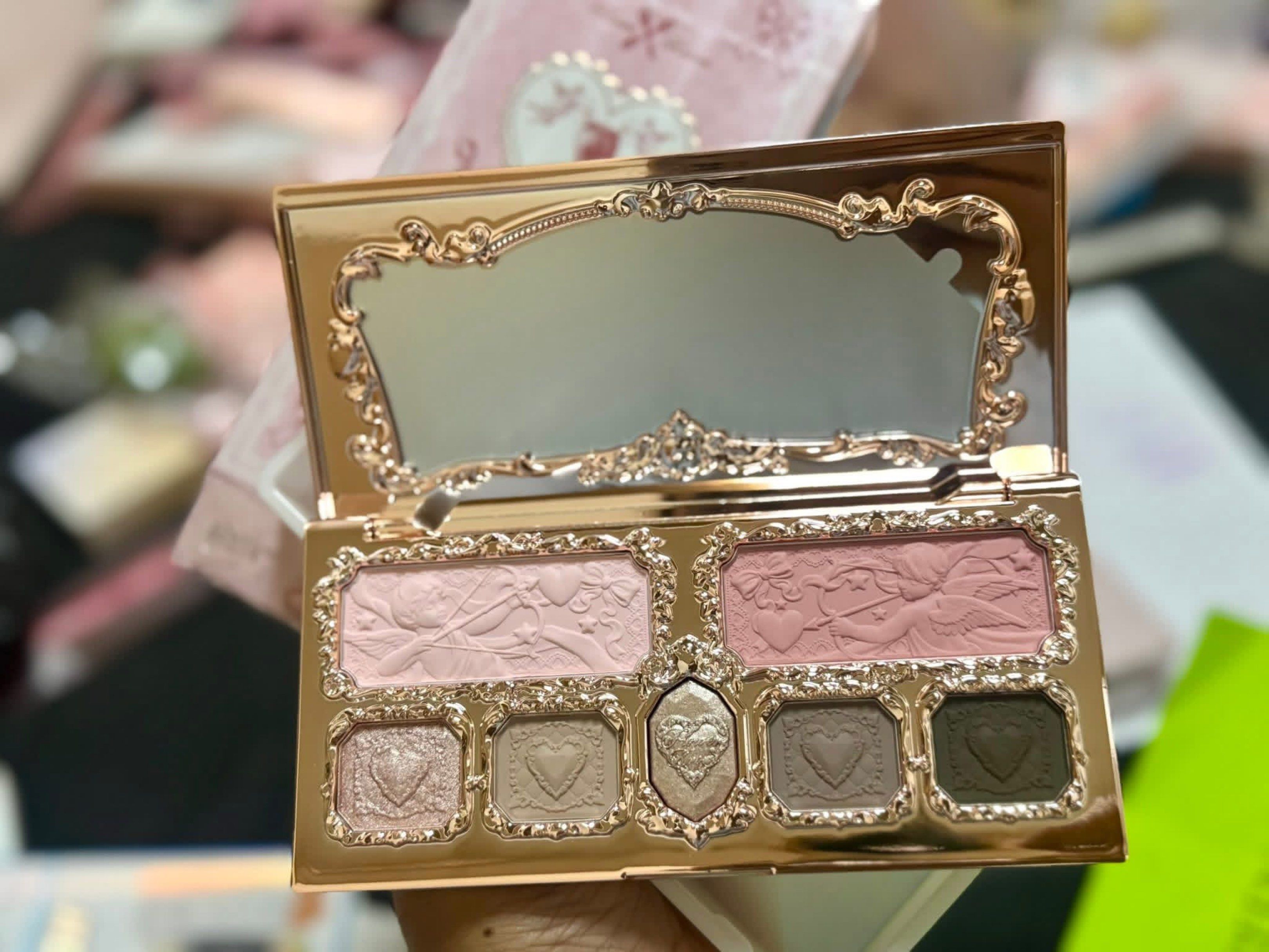 Flower knows Strawberry Eyeshadow Palette (Category: Makeup) located in Manila. Submitted by n4thlie (Listing ID 1419561792, Image 2). Description: - Strawberry-themed eyeshadow palette - Includes a mirror - Features a variety of eyeshadow shades: pinks, browns, and a darker green - Gold-colored case with a decorative, ornate design featuring cherubs and a strawberry centerpiece.