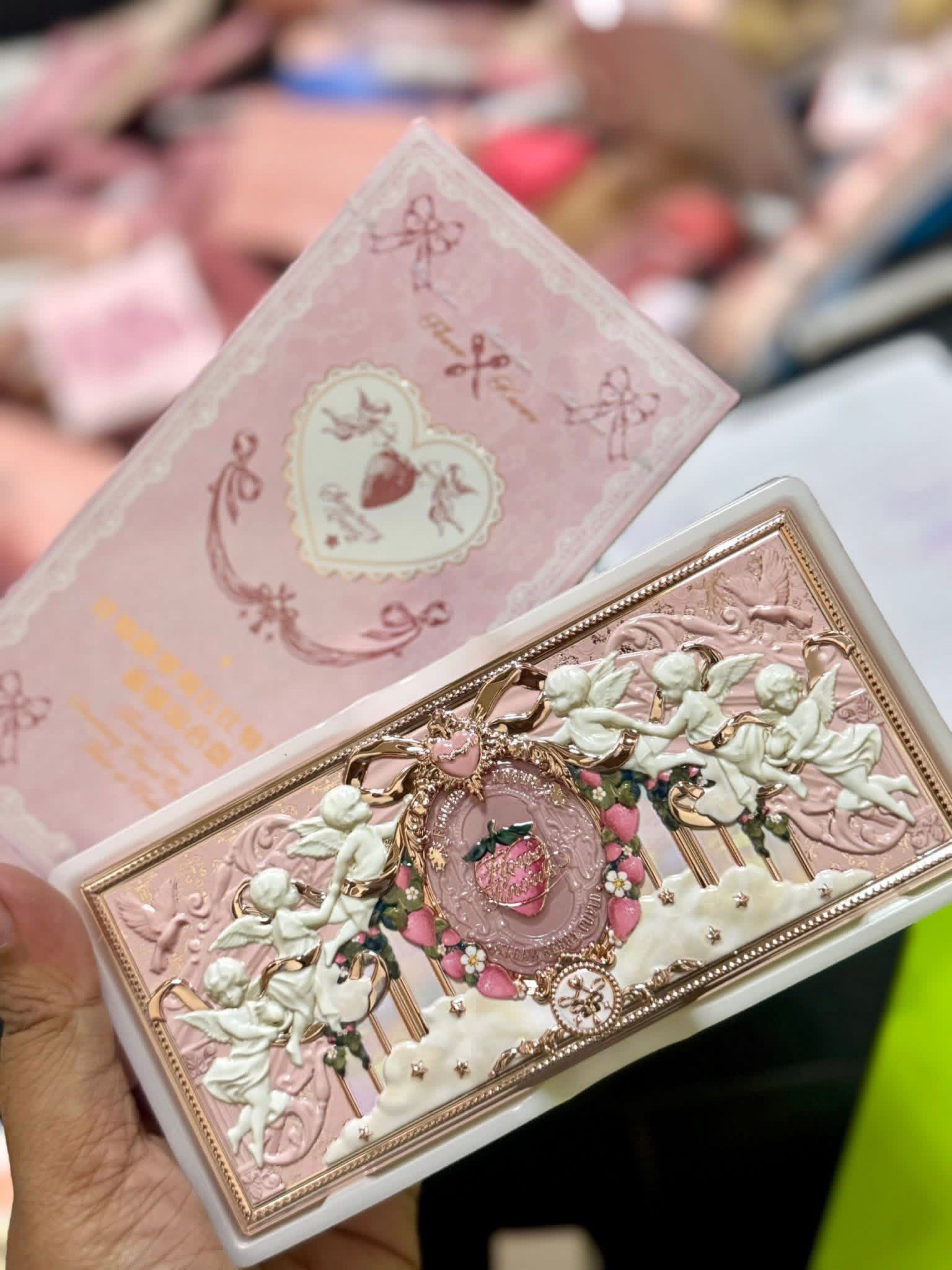 Flower knows Strawberry Eyeshadow Palette (Category: Makeup) located in Manila. Submitted by n4thlie (Listing ID 1419561792, Image 1). Description: - Strawberry-themed eyeshadow palette - Includes a mirror - Features a variety of eyeshadow shades: pinks, browns, and a darker green - Gold-colored case with a decorative, ornate design featuring cherubs and a strawberry centerpiece.