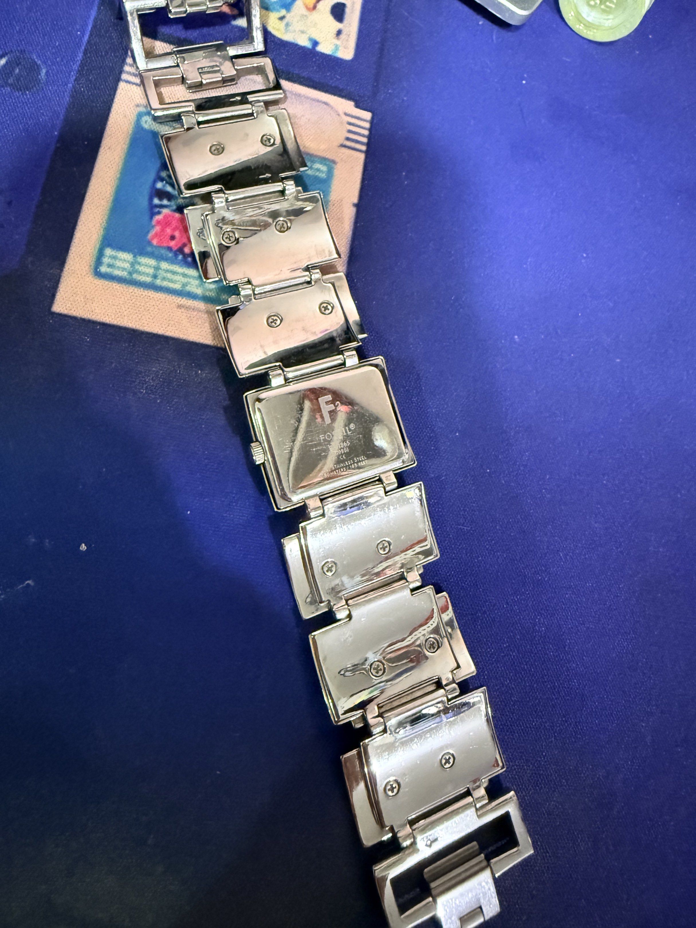 Fossil F2 ES1865 Pre loved (Category: Women's Watches) located in Quezon City. Submitted by decluttererwhenever (Listing ID 1419533482, Image 3). Description: - Fossil watch - Silver rectangular face - Silver band with rectangular links - White sunburst dial - Fossil logo visible on the back - No box - Bracelet length 17.5 cm (as shown on the photo) Payment arrangement: Half downpayment required so I can proceed with the battery replacement and m