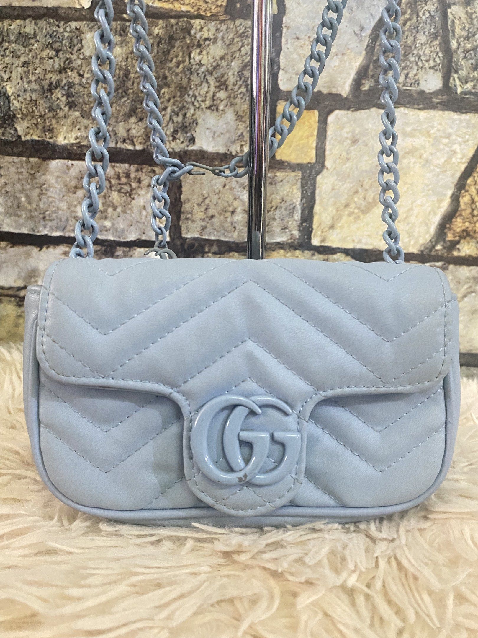 Gucci GG Marmont Mini Bag (Category: Luxury Bags & Wallets) located in Davao. Submitted by cmbrandedluxurycollection (Listing ID 1419517899, Image 2). Description: - Gucci GG Marmont Mini Bag - Light blue quilted design - Iconic GG logo on flap closure - Chain strap - Interior includes a small pocket - Leather tag with Gucci logo and "Made in Italy" inscription - Serial number tag inside.