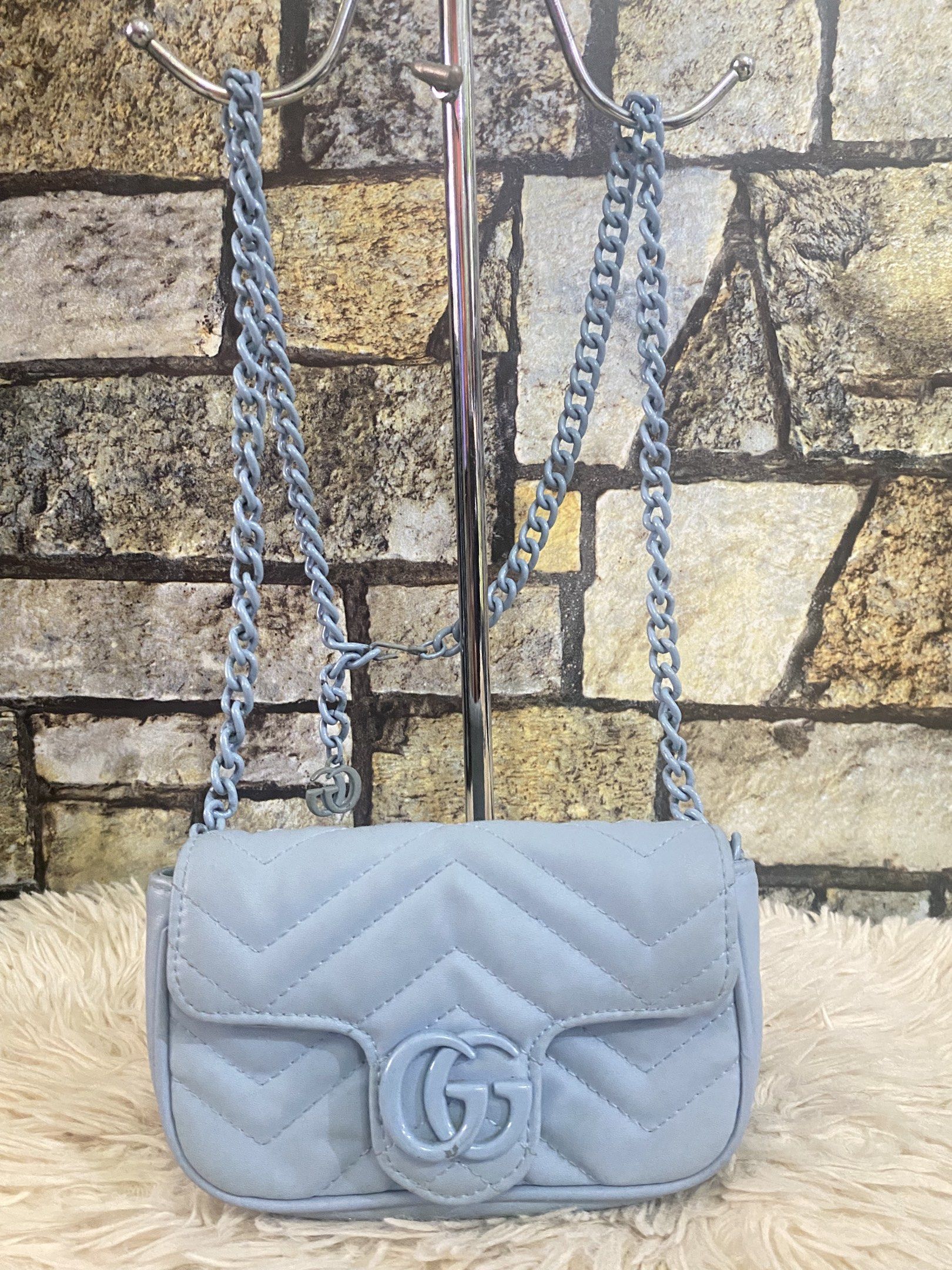 Gucci GG Marmont Mini Bag (Category: Luxury Bags & Wallets) located in Davao. Submitted by cmbrandedluxurycollection (Listing ID 1419517899, Image 1). Description: - Gucci GG Marmont Mini Bag - Light blue quilted design - Iconic GG logo on flap closure - Chain strap - Interior includes a small pocket - Leather tag with Gucci logo and "Made in Italy" inscription - Serial number tag inside.