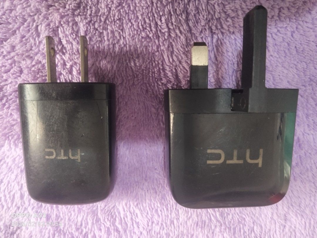 HTC Charger Package (Category: Chargers & Cables) located in Carmona. Submitted by rpute (Listing ID 1419403220, Image 1). Description: - HTC charger - USB port - Includes US and UK plug types - Black color - HTC logo visible.