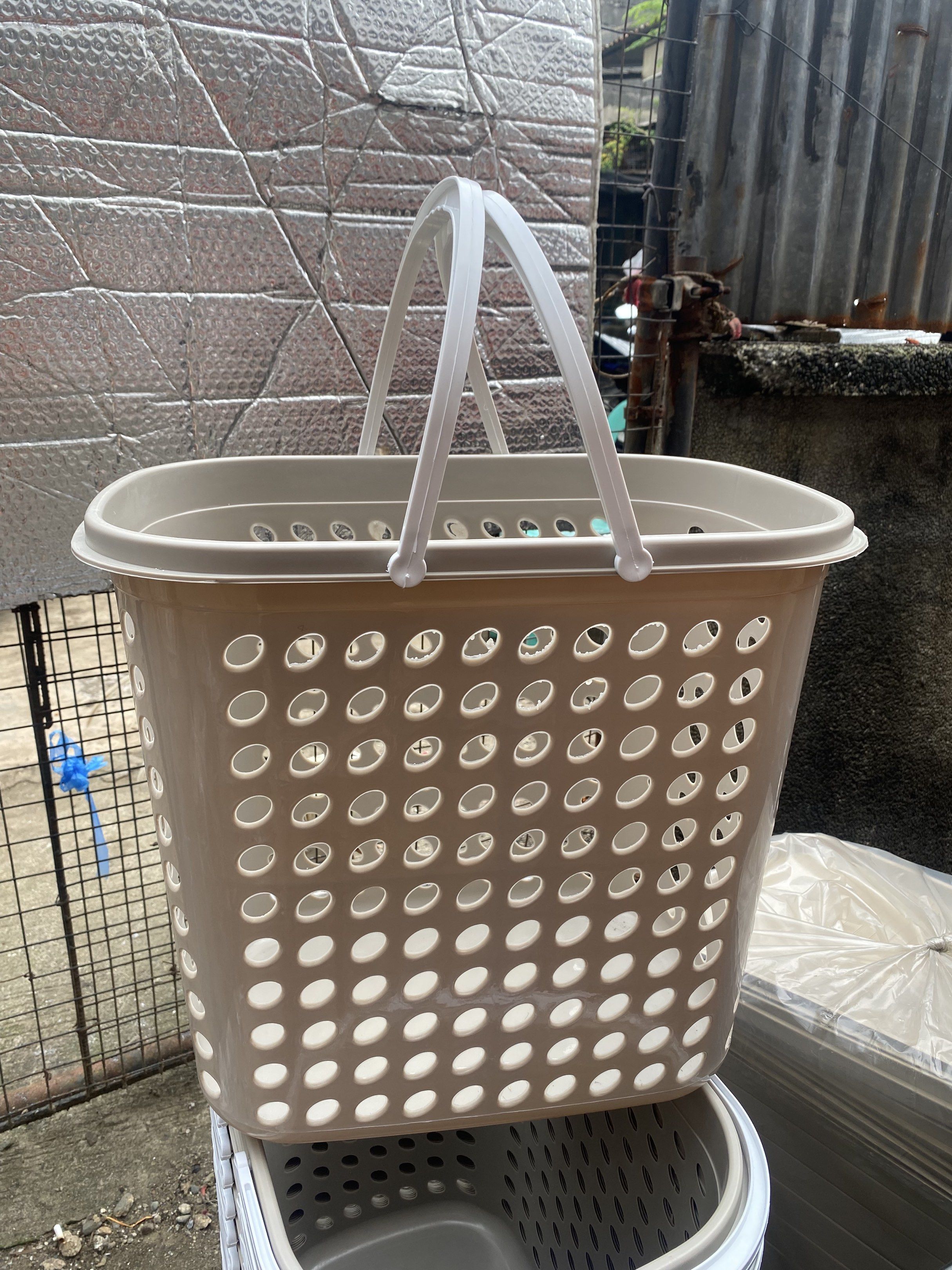 Laundry Basket with Handles (Category: Laundry Baskets) located in Caloocan City. Submitted by brightdeer.83db1b (Listing ID 1419518840, Image 1). Description: - Durable plastic laundry basket - Rectangular shape with perforated design - Features two white handles - Neutral beige color - Standard size - Suitable for laundry or storage - Sturdy and clean appearance.