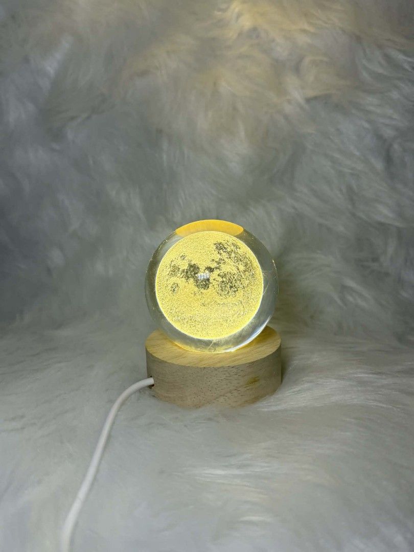 Moon Crystal Ball Night Light Side-table Night Light Moon Lamp (Category: Lighting) located in Manila. Submitted by abcdcv (Listing ID 1419435495, Image 1). Description: - Crystal ball night light with moon design - Features a wooden base - Powered via USB cable - Emits a warm, yellow light - Brand new, in original packaging.