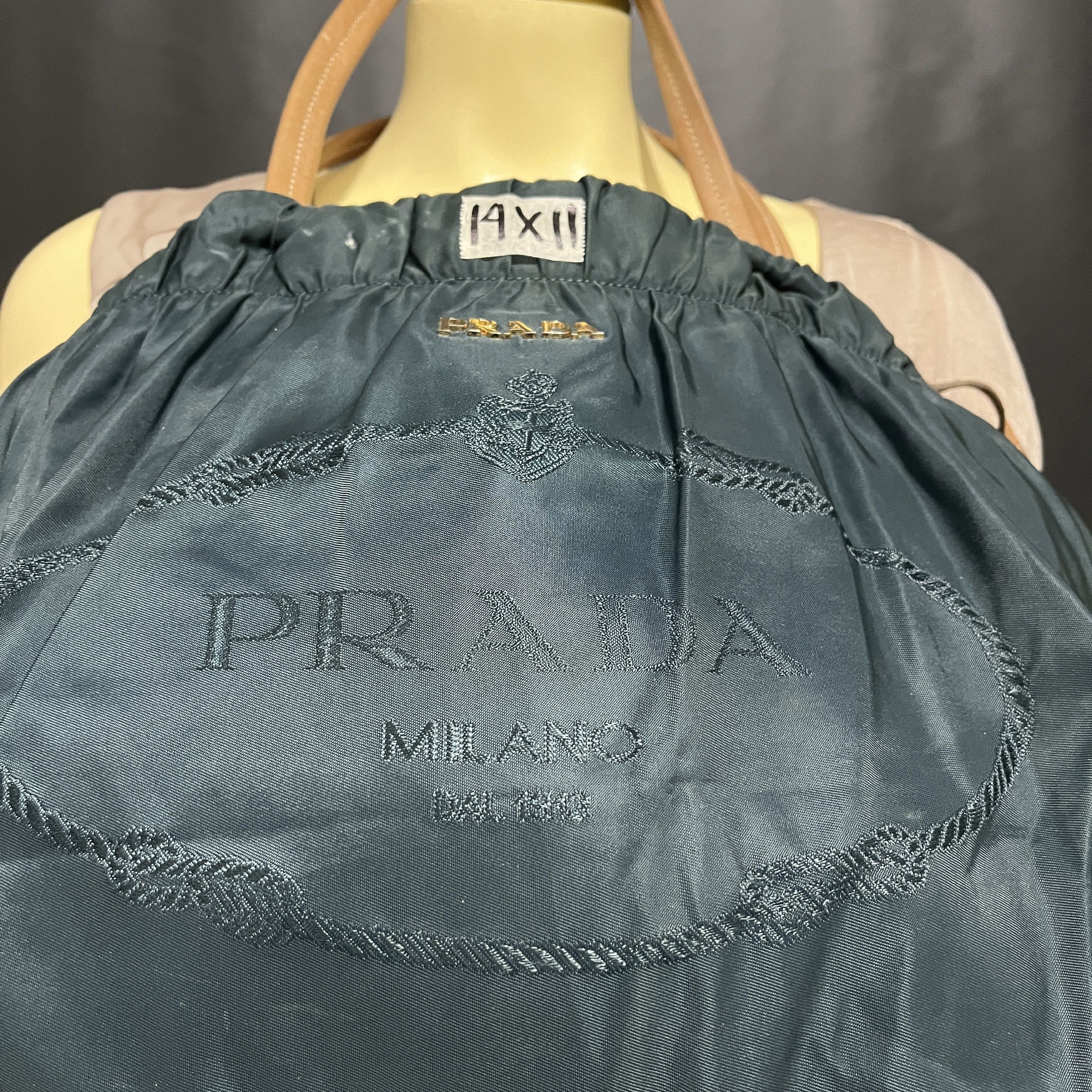Prada Drawstring Tote Bag (Category: Luxury Bags & Wallets) located in Butuan. Submitted by dfgthriftology2.0 (Listing ID 1419544662, Image 2). Description: - Teal nylon exterior - Leather handles - Drawstring closure - Prada logo embroidery - Interior zipper pocket - Leather tag with Prada logo - Gold-tone hardware.
