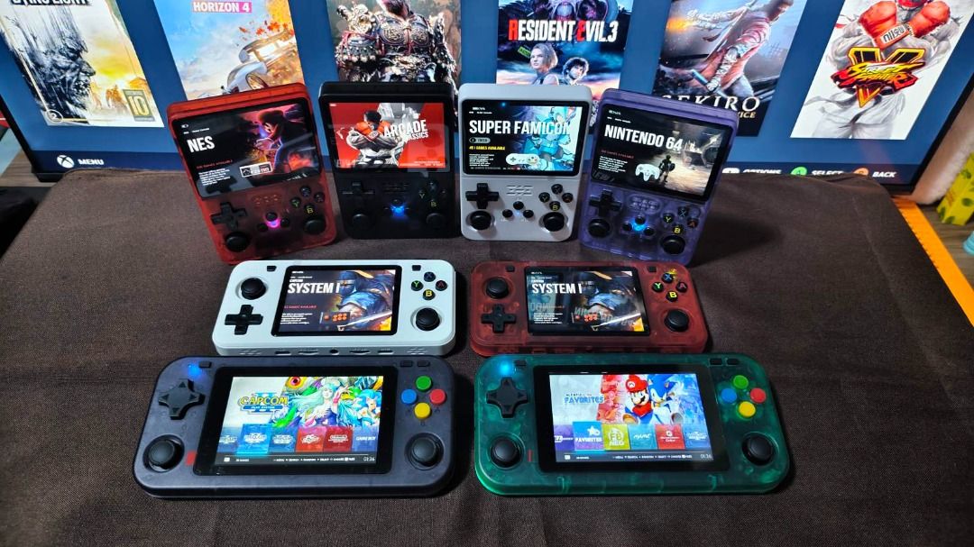 Retro Handheld Game Console (Category: Others) located in Davao. Submitted by leovanniem23152 (Listing ID 1419398131, Image 3). Description: Collection of retro handheld game consoles in various colors. Each console features a screen displaying different game interfaces. The consoles have a D-pad, buttons, and analog sticks. Some consoles show NES, Super Famicom, and Nintendo 64 game interfaces. The consoles come in red, black, white, gray, and g