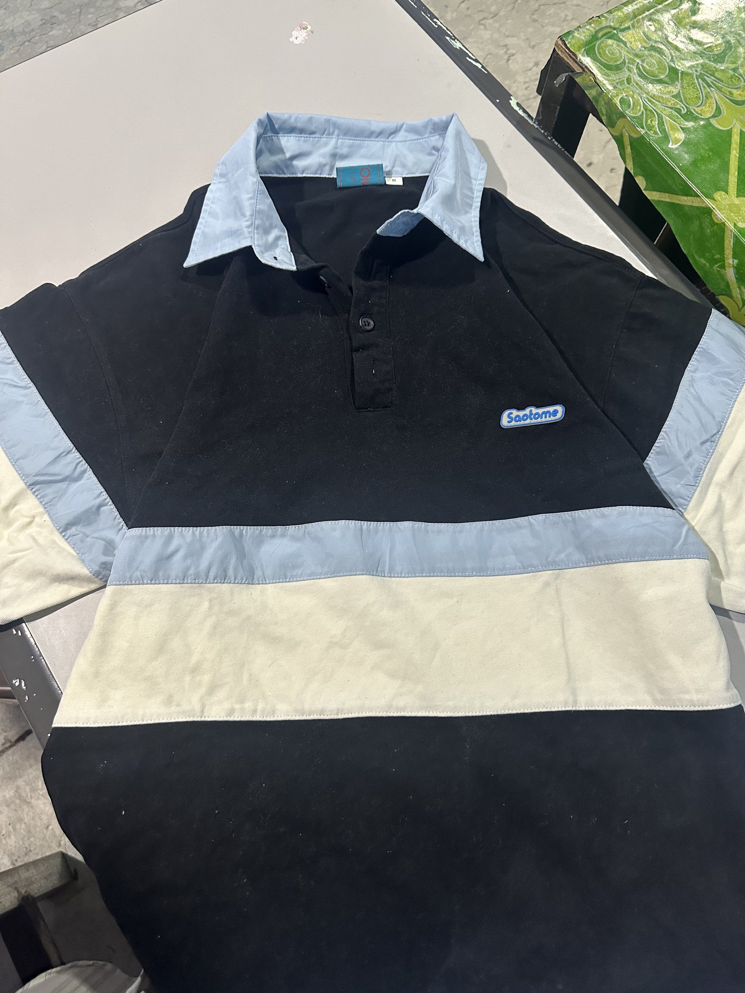 Saotome Polo Shirt - Size S (Category: Tshirts & Polo Shirts ) located in Manila. Submitted by 143aly (Listing ID 1419396137, Image 2). Description: - Saotome polo shirt - Color: Black body with light blue collar and accents - Size: Small but can fit to medium to large - Design: Button-down - Features: Small Saotome logo on chest.