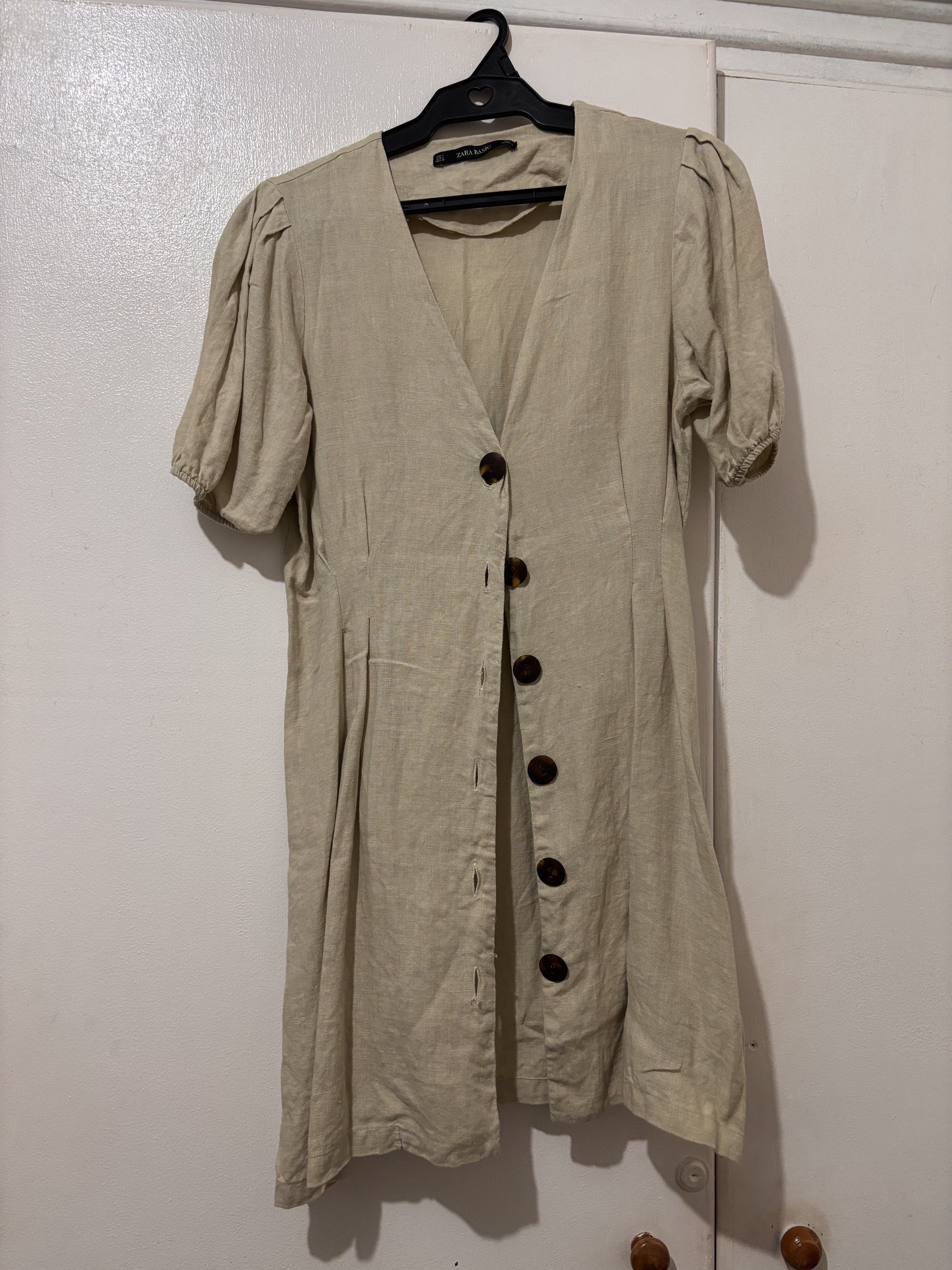 Zara Linen Dress (Category: Dresses) located in Pasig City. Submitted by pattycakez (Listing ID 1419526492, Image 1). Description: - Zara Basic dress - V-neckline - Button-down closure - Short, puffed sleeves - Tailored silhouette - Neutral beige color - Size: S - Made in Morocco.