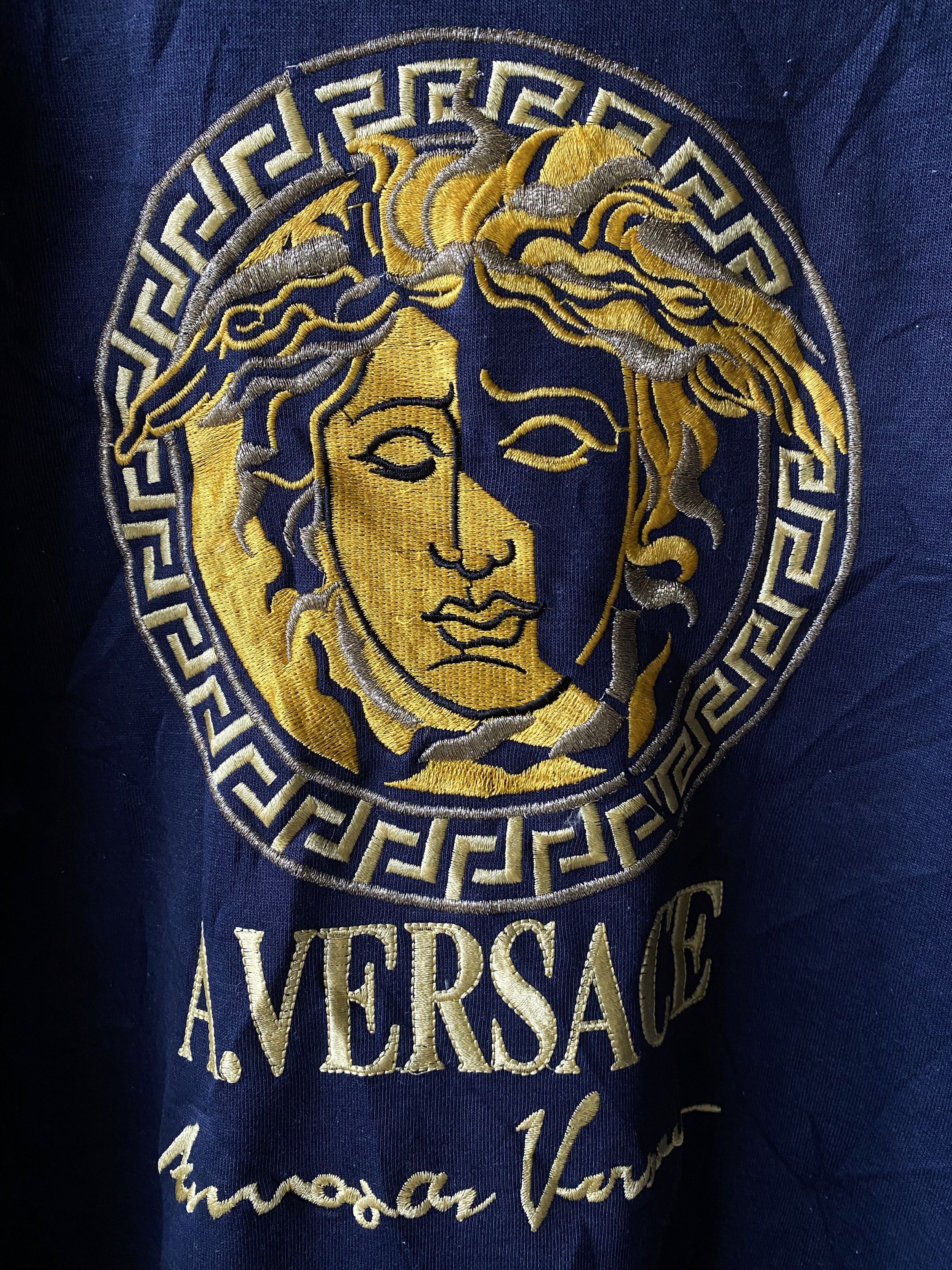 A. Versace Medusa Sweatshirt - Navy Blue (Category: Coats, Jackets and Outerwear) located in Tuguegarao City. Submitted by thriftnigelo (Listing ID 1419595389, Image 2). Description: Navy blue A. Versace sweatshirt featuring a gold Medusa head logo on the front. The label indicates it's from A.V. Versace Diffusion line. It has a crew neck and long sleeves. The size is medium. The sweatshirt has a vintage look..