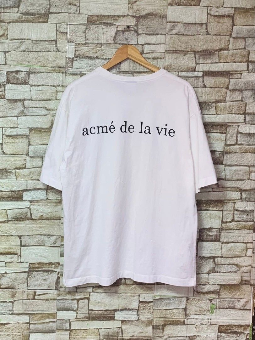 Acme De La Vie Donut Graphic Tee (Category: Tshirts & Polo Shirts ) located in Caloocan City. Submitted by vintstreets (Listing ID 1419734332, Image 2). Description: ADLV • Dimes: width: 22 Length: 28 • Condition & Color rate: 9.2/10 • makapal tela • solid print nito • light stain pinaka ilalim pero hindi sya visible ha 📍 South Caloocan 🚚 JNT - ADLV white t-shirt - Features a graphic of a girl holding donuts - Brand name printed on the back - S