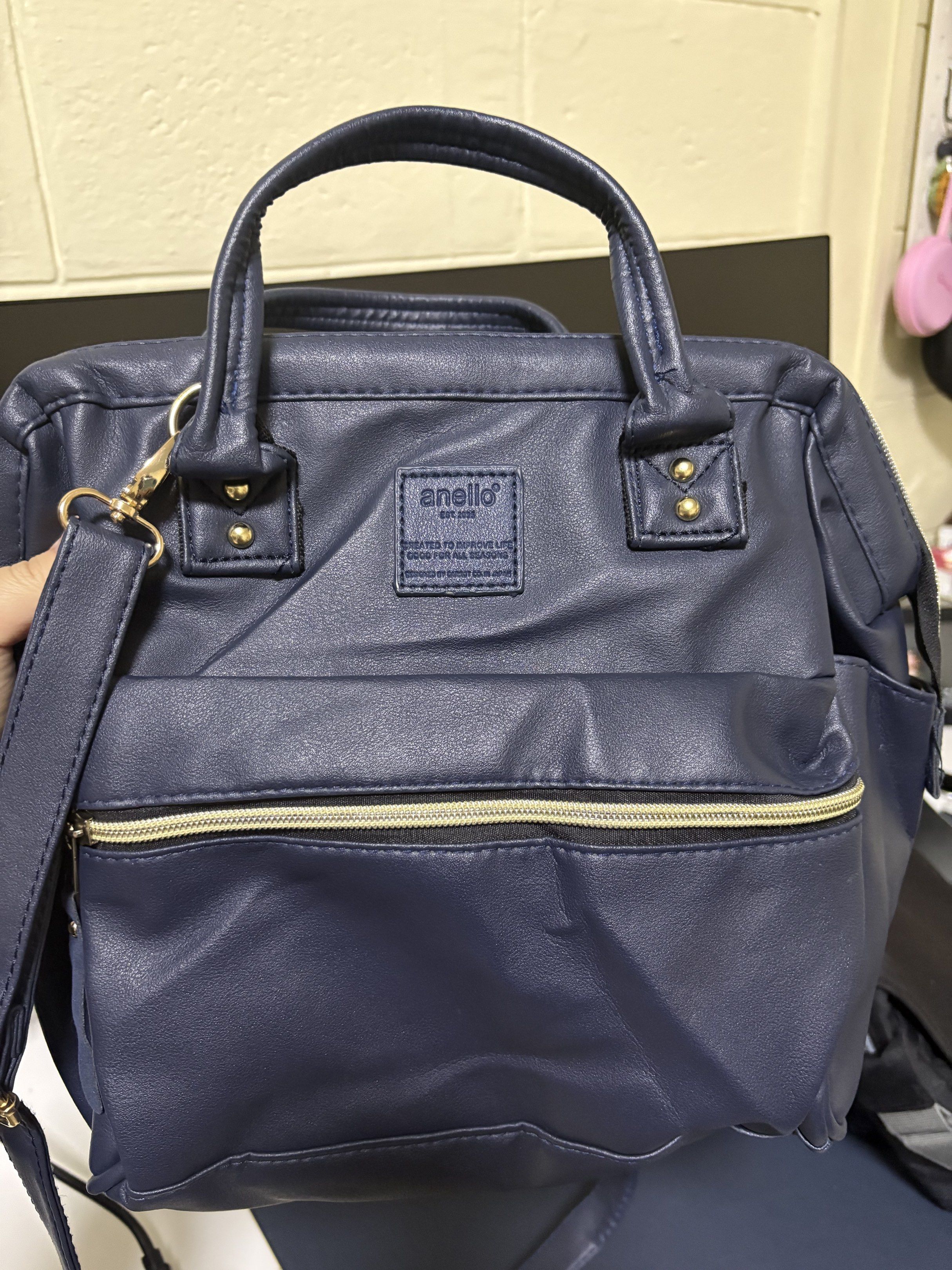 Anello 2-Way Mini Handbag - Navy Blue (Category: Cross-body Bags) located in Manila. Submitted by bearfruit (Listing ID 1419597462, Image 1). Description: - Anello 2-way mini handbag - Color: Navy Blue - Features: - Top handle - Detachable shoulder strap - Front zippered pocket - Side pockets - Gold-colored hardware - Main compartment zipper - Anello logo on front - Material: Leather-like.