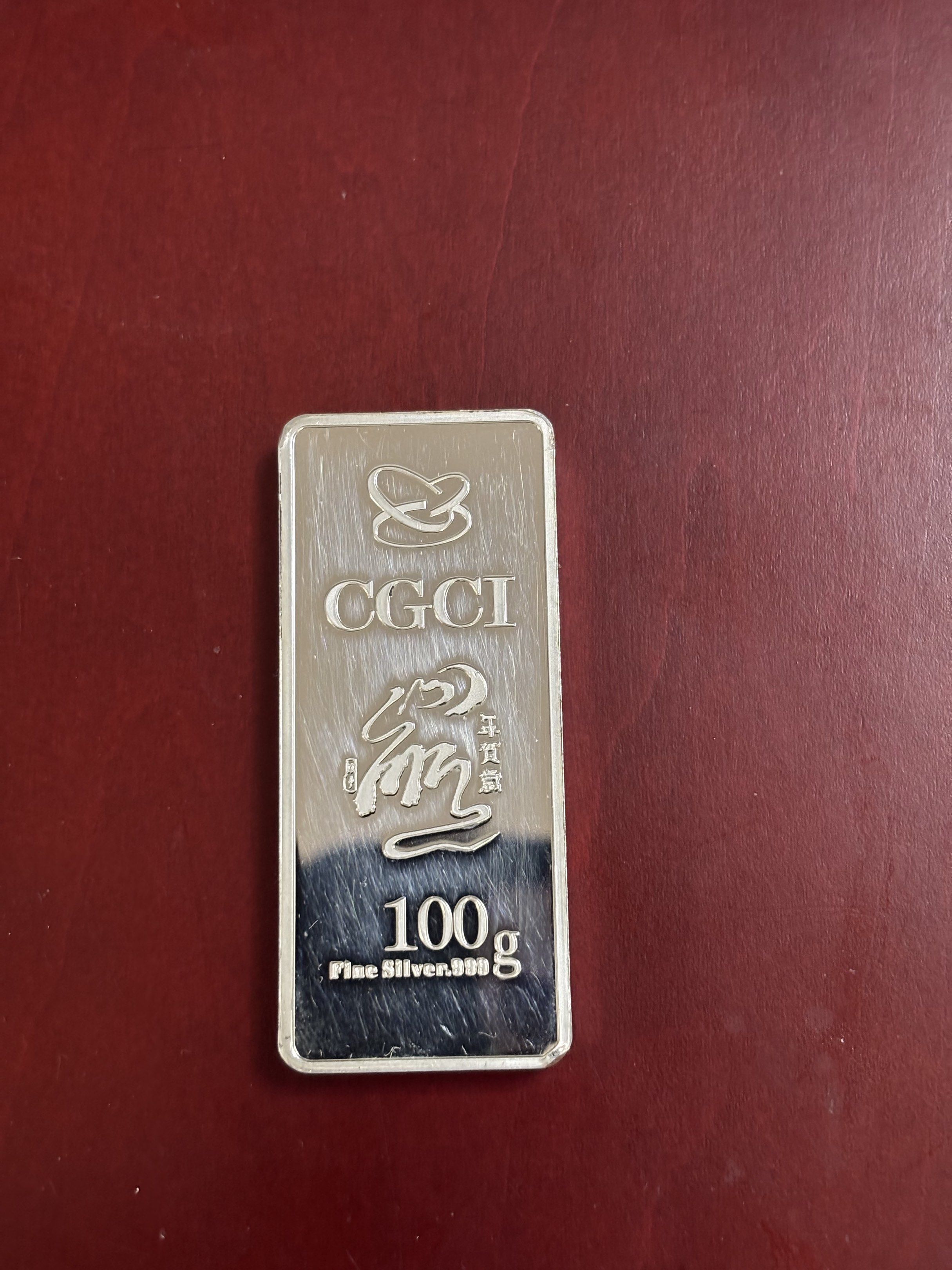 CGCI 100g Fine Silver Bar .999 (Category: Currency) located in Paranaque City. Submitted by jorgeramos878 (Listing ID 1419609183, Image 2). Description: - CGCI 100g Fine Silver Bar - Features a Year of the Rat design - Front: Image of a rat and Chinese characters - Back: CGCI logo, Chinese characters, and weight - Rectangular shape.