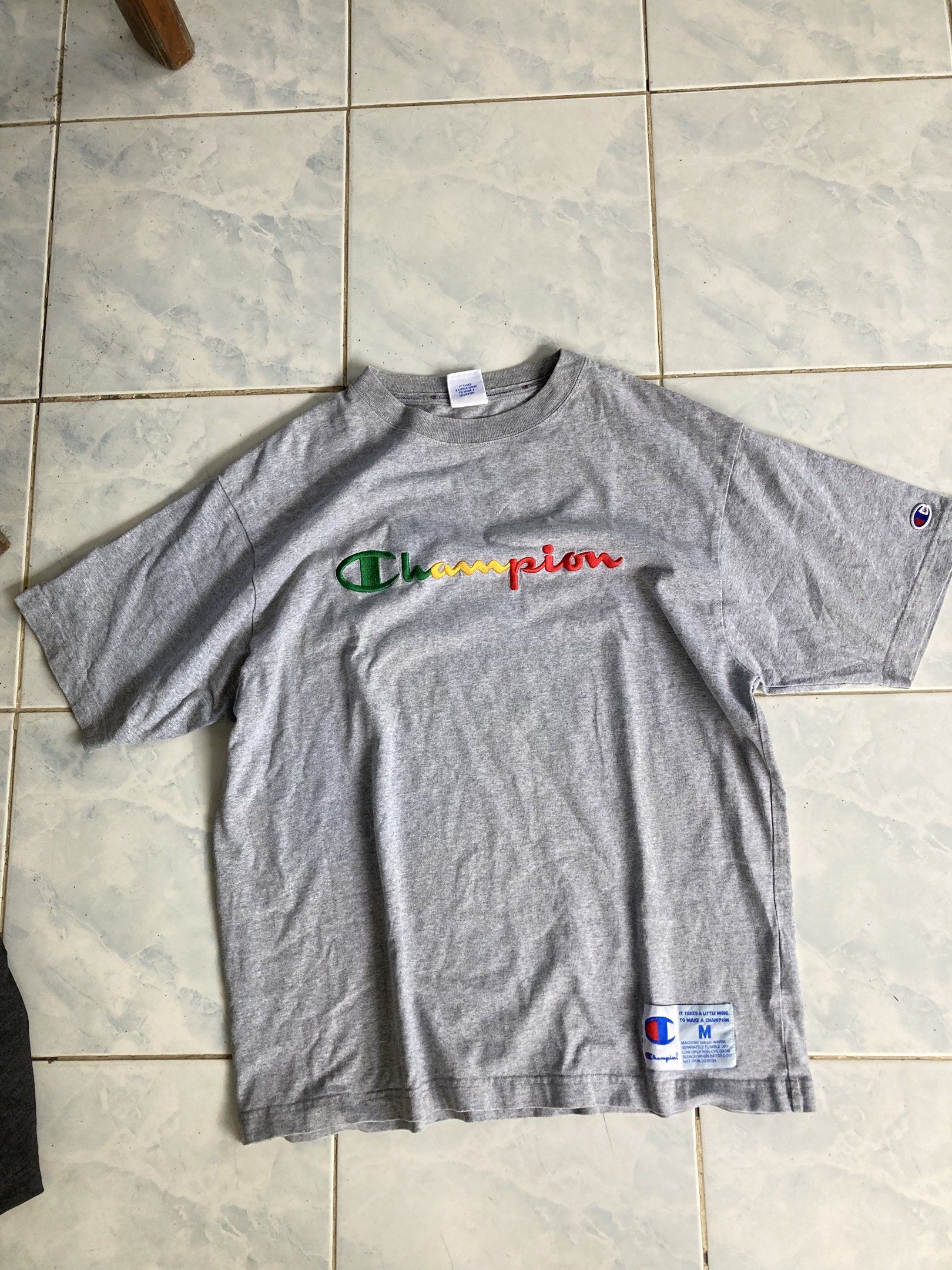 Champion Embroidered Logo T-shirt - Medium (Category: Tshirts & Polo Shirts ) located in Tarlac. Submitted by everthrift (Listing ID 1419776559, Image 1). Description: - Gray Champion t-shirt - Embroidered Champion logo (green, yellow, red) - Crew neck - Short sleeves - Size: Medium - Champion logo on sleeve - Made in USA .
