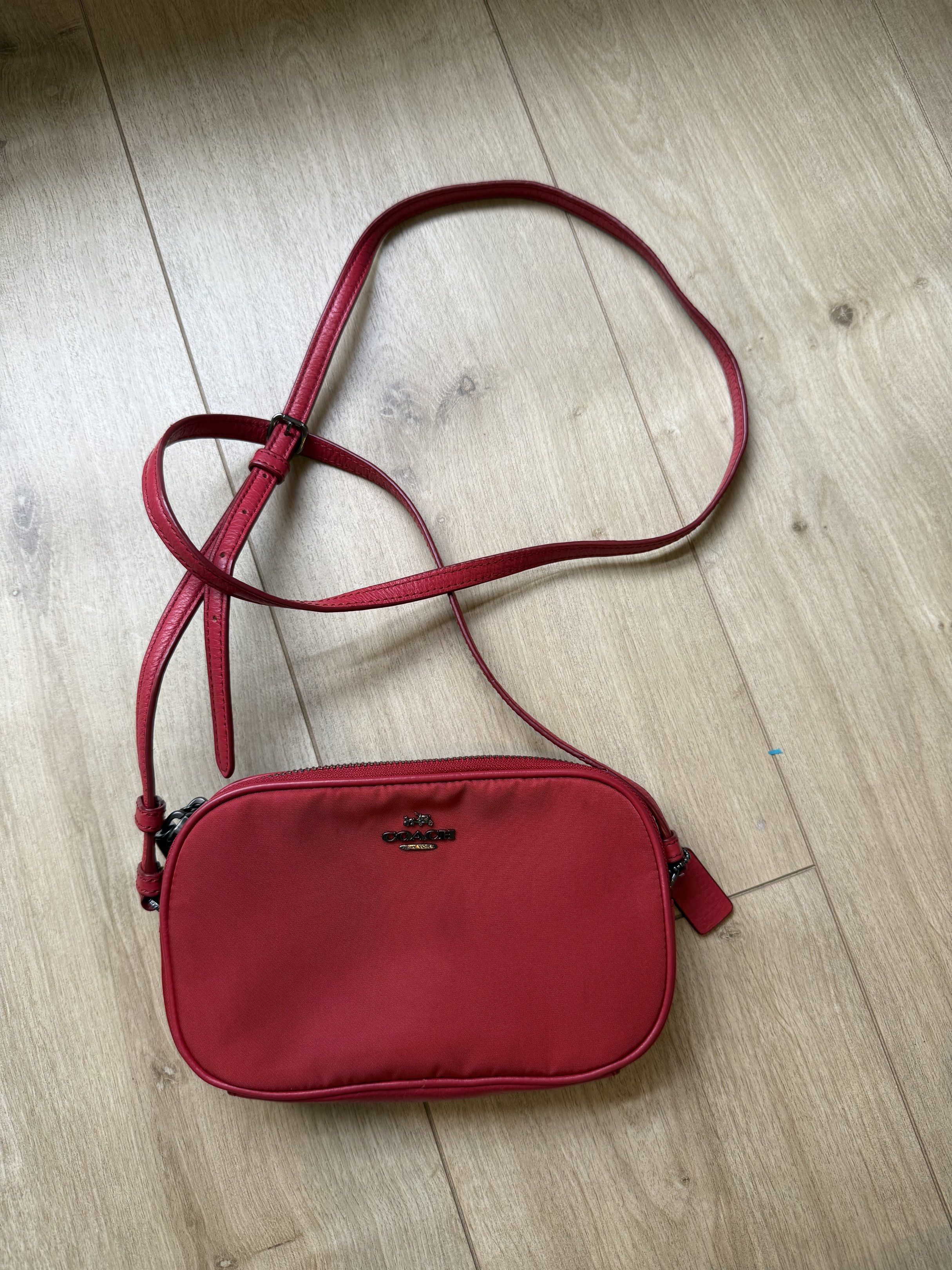 Coach Red Crossbody Bag (Category: Luxury Bags & Wallets) located in Paranaque City. Submitted by rymss (Listing ID 1419635653, Image 1). Description: - Brand: Coach - Color: Red - Style: Crossbody bag - Features: Zip closure, adjustable strap, Coach logo - Material: Possibly nylon - Size: Compact, ideal for essentials.
