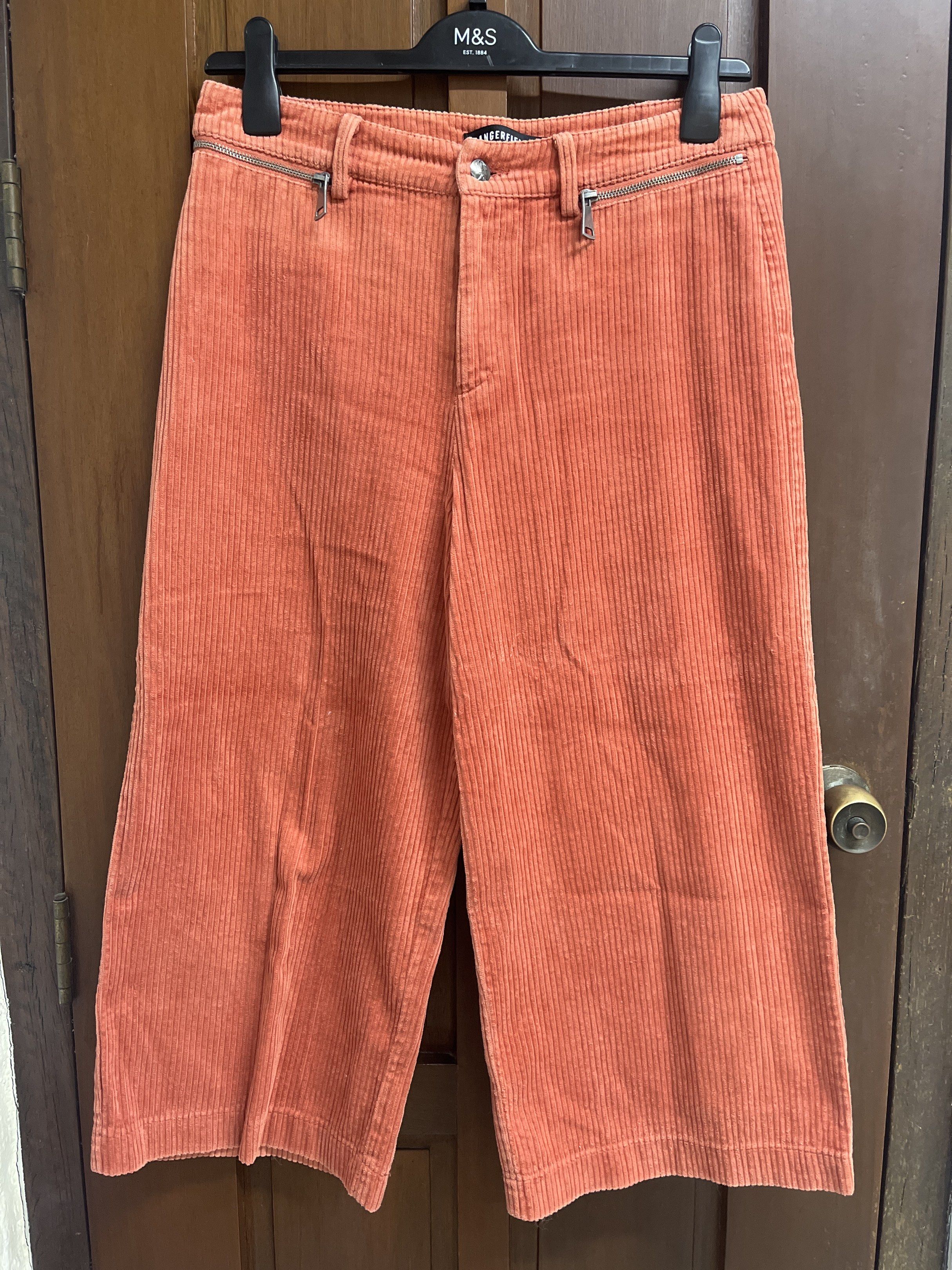 Dangerfield Corduroy Culottes (Category: Other Bottoms) located in Muntinlupa City. Submitted by timttam (Listing ID 1419720200, Image 1). Description: - Dangerfield corduroy culottes - Vibrant orange color - Wide-leg design - Button and zipper closure - Features front and back pockets - Comfortable and flattering fit - Perfect for a stylish look.