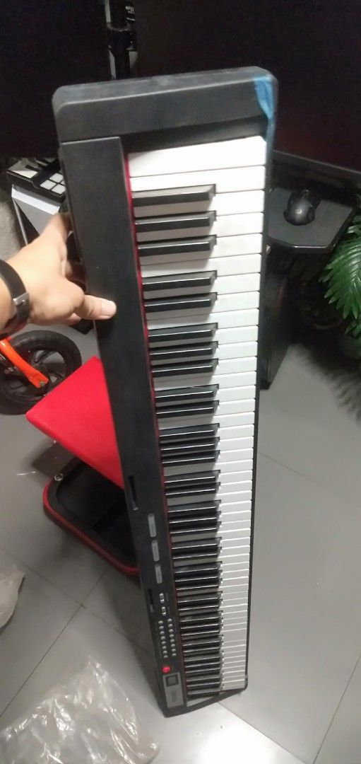 Digital Piano (Category: Musical Instruments) located in Mandaluyong City. Submitted by allinthehood (Listing ID 1419594488, Image 2). Description: - Full-size keys - Black and red casing - White and black keys - Portable design - Ideal for practice or performance - Model number visible.
