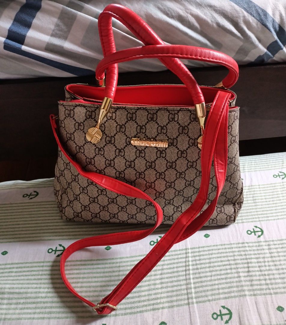 Gidebam Handbag with Red Accents (Category: Cross-body Bags) located in Manila. Submitted by iyasgagui26502 (Listing ID 1419641953, Image 1). Description: Stylish handbag featuring a brown and beige GD pattern with red handles and strap. The interior is red with multiple compartments, including a zippered pocket. It has gold-colored hardware and a Gidebam logo. Includes a detachable shoulder strap for versatile carrying options..