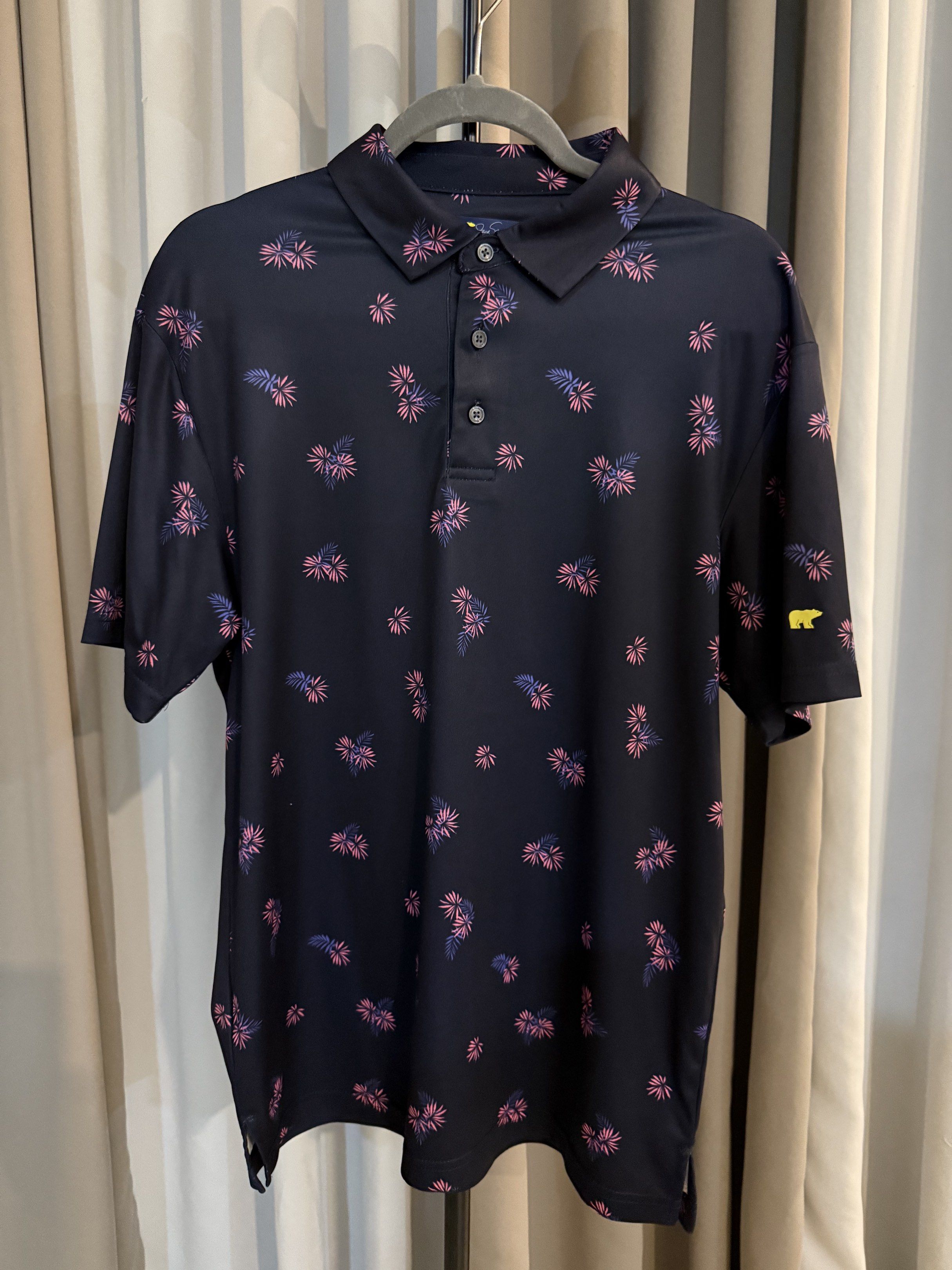 Jack Nicklaus Floral Polo Shirt (Category: Tshirts & Polo Shirts ) located in Bacolod City. Submitted by sunbird_collection (Listing ID 1419708722, Image 1). Description: - Jack Nicklaus polo shirt - Navy blue base - Floral pattern in pink and purple - Classic polo collar - Three-button placket - Short sleeves - Yellow bear logo on left sleeve - Size: M/M Fit: True to Size.