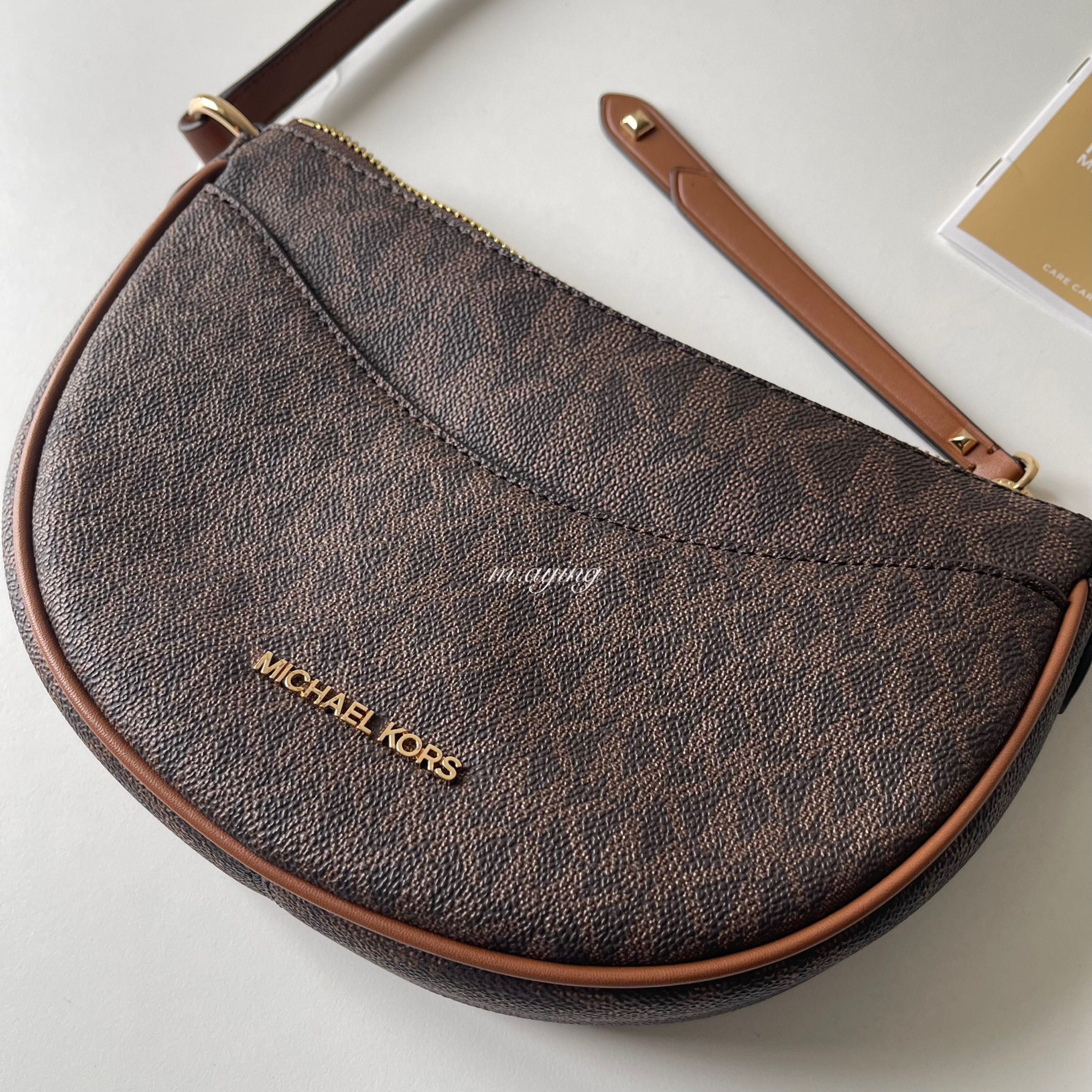 Michael Kors Dover Crossbody Bag (Category: Luxury Bags & Wallets) located in Mandaluyong City. Submitted by momandbabystuffph (Listing ID 1419629926, Image 3). Description: - Michael Kors crossbody bag - Brown signature print - Half-moon shape - Main compartment with zipper closure - Interior pocket - Michael Kors logo on front - Includes original price tag.