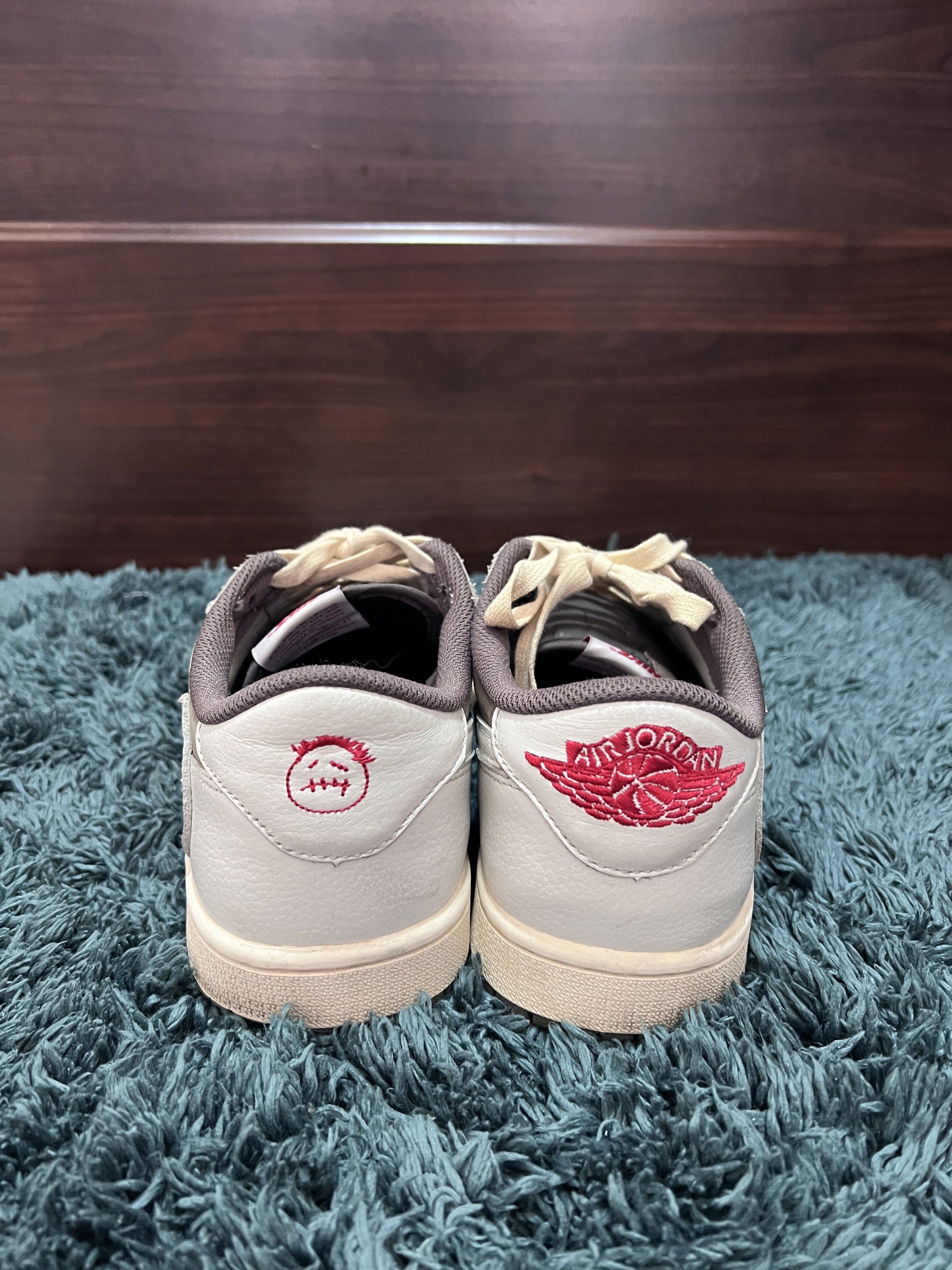 Nike Air Jordan 1 Low Travis Scott (Category: Sneakers) located in Manila. Submitted by julia.irene (Listing ID 1419651569, Image 1). Description: These sneakers feature a white and brown colorway with the iconic Travis Scott design elements. The shoes have the Air Jordan logo on the back and the Travis Scott face logo on the other. The soles are brown. The insoles have the Nike Air logo and the word "TRAV" on one shoe and the Air Jordan logo on 