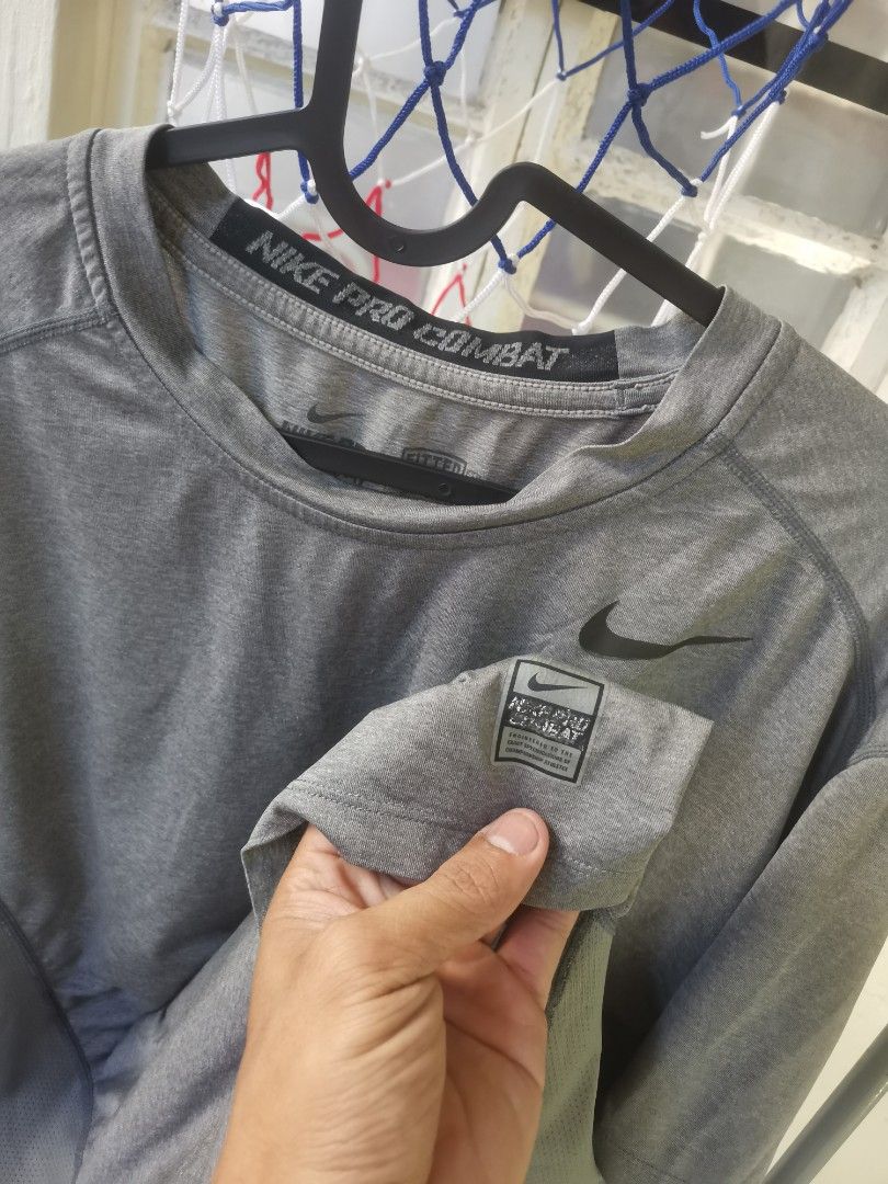 Nike Pro Combat Gray Shirt compression (Category: Activewear) located in Baliuag. Submitted by rjpagaduan (Listing ID 1419721013, Image 3). Description: - Gray Nike Pro Combat shirt - Nike logo on chest - Pro Combat branding on collar - Crew neck and short sleeves - Minor flaw: small hole on the side - Made with breathable material.