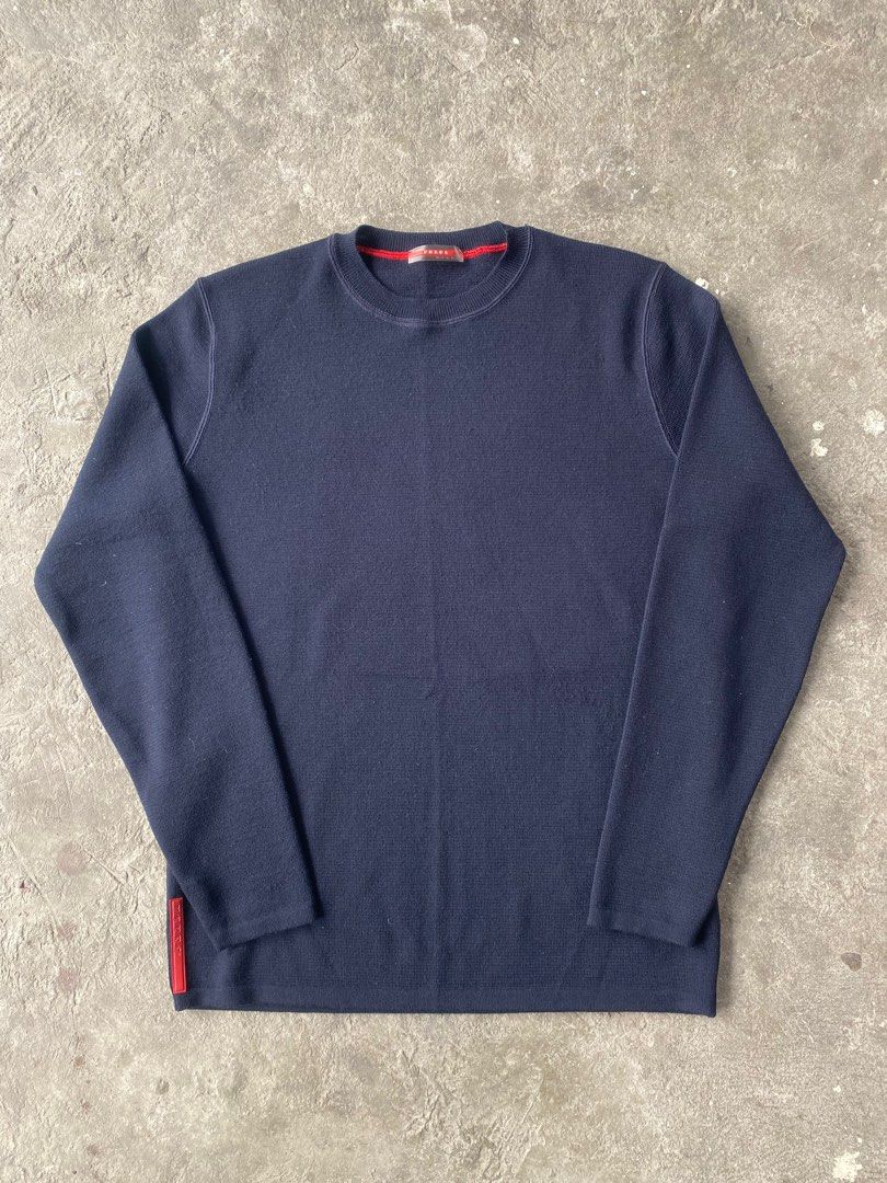 Prada Navy Blue Wool Sweater (Category: Luxury Apparel) located in Lipa City. Submitted by dcd1217 (Listing ID 1419746771, Image 1). Description: - Authentic Prada sweater - Made in Italy - Color: Navy blue with red trim - Crew neck - Long sleeves - Features Prada logo red tab - Material: 100% wool Size 46 on tag Fit M-L Excellent condition Message me for any concerns.