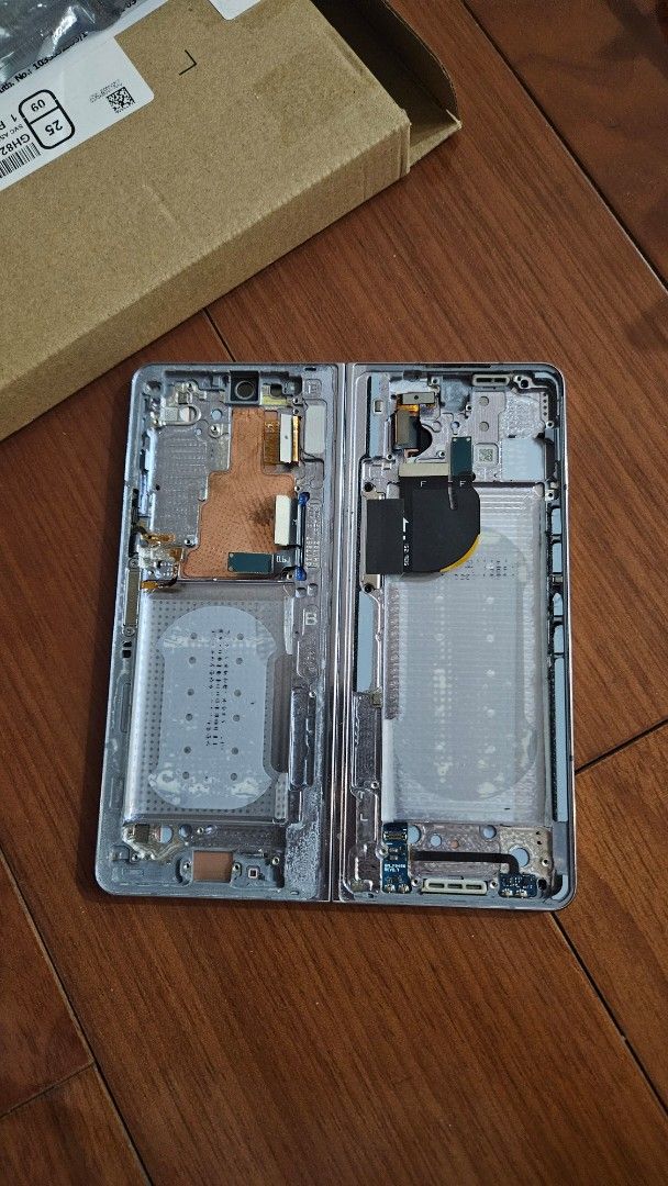 Samsung Galaxy Fold 5 part (Category: Samsung) located in Quezon City. Submitted by brigdog (Listing ID 1419608769, Image 1). Description: - Samsung foldable phone damaged part - Disassembled, showcasing internal components - Silver frame for Fold 5 damaged - Samsung logo present - this was taken out from a phone because of the damaged part .