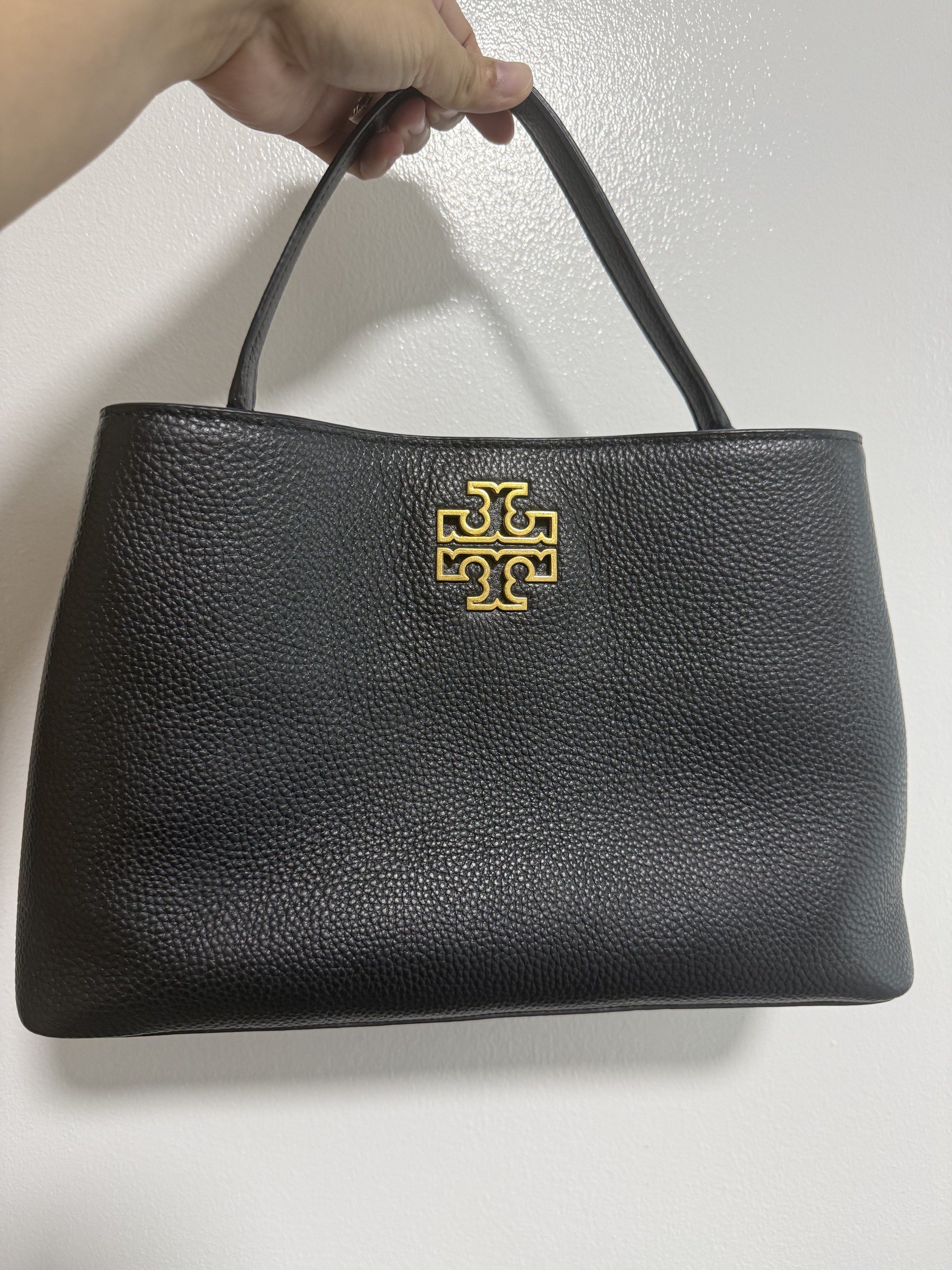 Tory Burch Black Leather Handbag (Category: Luxury Bags & Wallets) located in Cavite. Submitted by nadine_1230 (Listing ID 1419640028, Image 1). Description: - Black leather handbag - Gold-tone logo - Top handle - Spacious interior - Zippered pocket - Textured leather exterior - Well-constructed - Structured shape - Classic design.