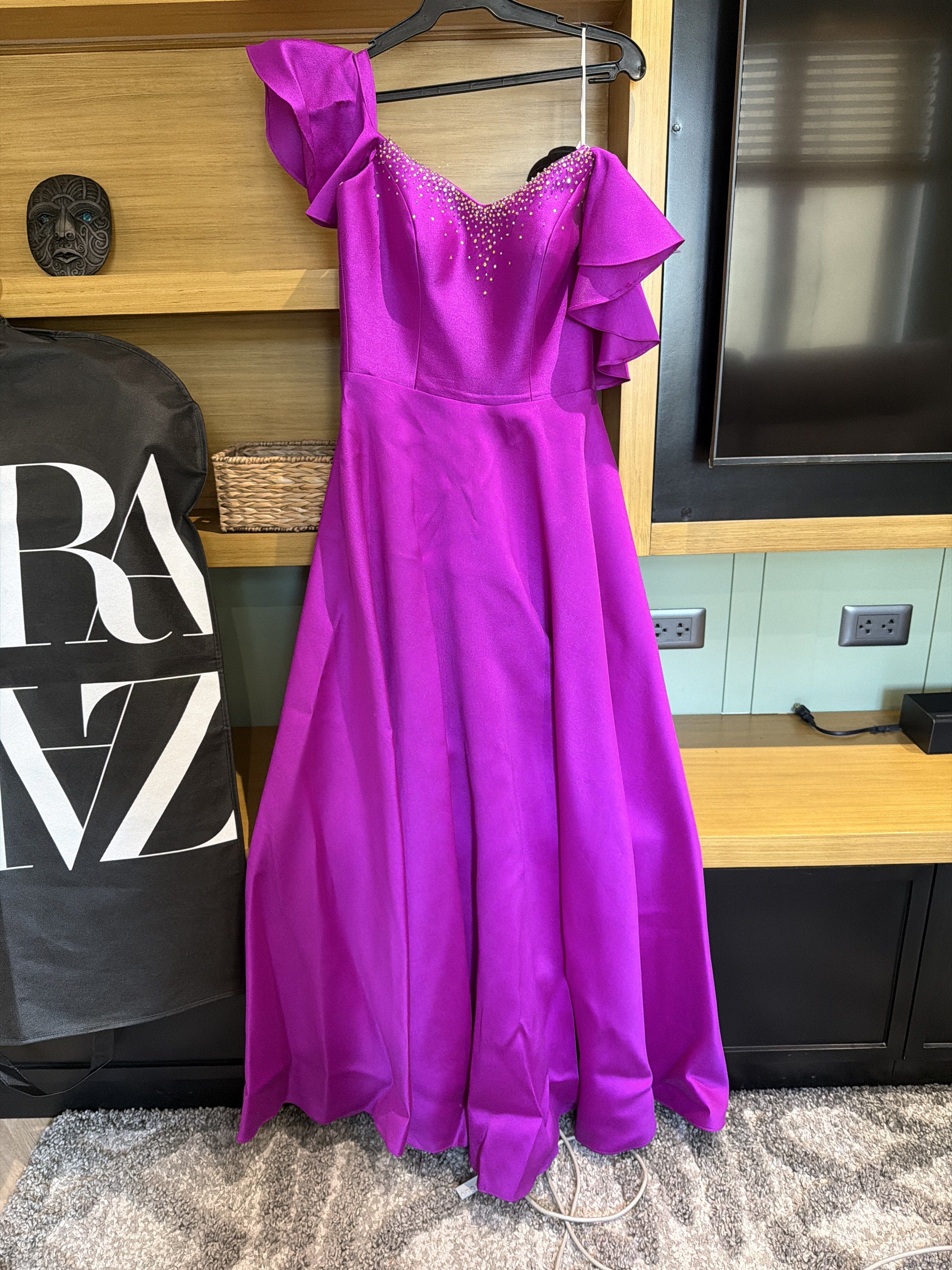 Vee Tan One-Shoulder Gown with slit (gazaar) (Category: Evening dresses & gowns) located in San Juan City. Submitted by closetsale28 (Listing ID 1419613434, Image 1). Description: - Vee Tan one-shoulder gown - Vibrant purple color - Flowing silhouette - Delicate bodice embellishments - Cascading shoulder ruffles - Concealed zipper closure - Perfect for formal events and special occasions.