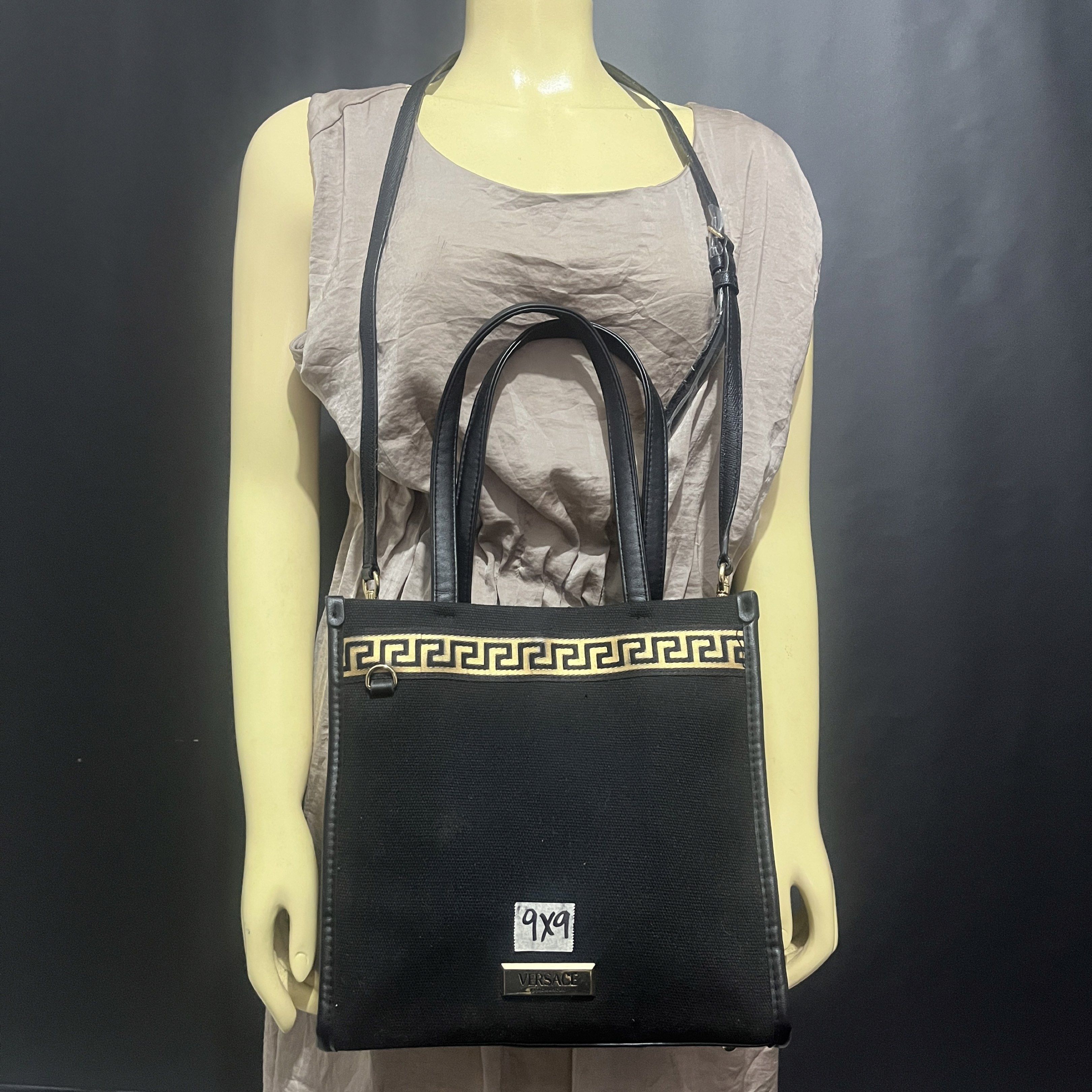 Versace Black Tote Bag with Shoulder Strap (Category: Luxury Bags & Wallets) located in Butuan. Submitted by dfgthriftology2.0 (Listing ID 1419721066, Image 1). Description: - Versace tote bag - Black canvas and leather exterior - Gold Greek key design - Detachable shoulder strap - Top handles - Rectangular shape - Black interior lining - Versace logo on front - Small interior pocket.