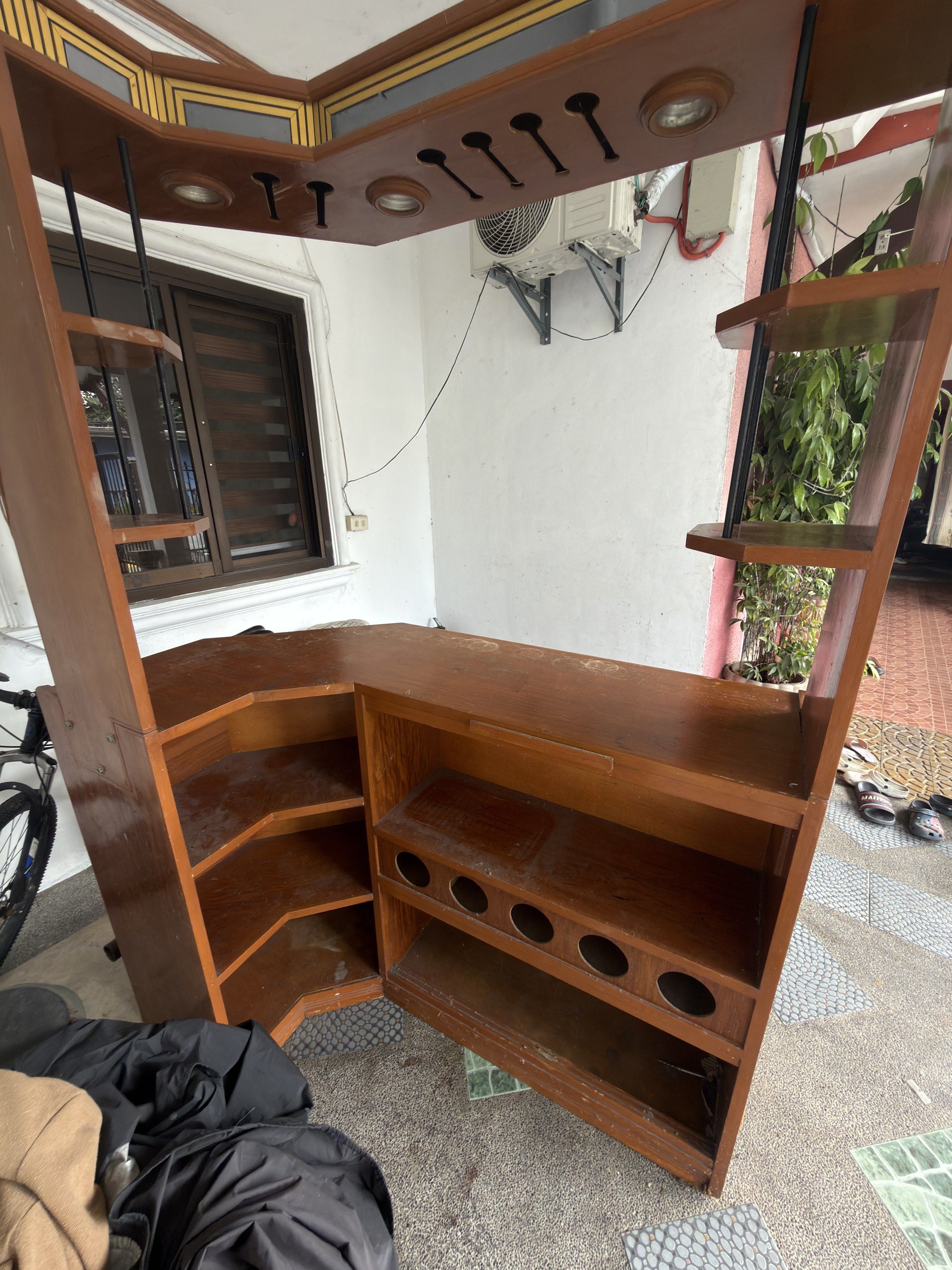 Wooden Bar with Shelves (Category: Shelves, Cabinets & Racks) located in Manila. Submitted by khaazzii11 (Listing ID 1419730047, Image 1). Description: - Wooden bar with multiple shelves - Built-in wine glass rack - Countertop included - Burgundy upholstered front - Built-in lighting - Unique corner design with side shelving - Perfect for home entertainment or small business use.