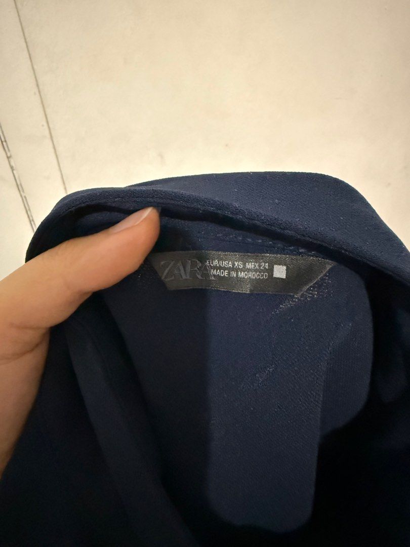 Zara Navy Blue High Neck Blouse (Category: Sleeveless) located in Malabon City. Submitted by decluttergyal (Listing ID 1419716475, Image 3). Description: - Zara navy blue top - Color: Navy blue - Size XS but can fit an S or even an M. - Features: Mock neck, button details on front, short sleeves - Made in Morocco - Used once for a work event then never again Tags: zara, blouse, work attire, mango, massimo dutti.