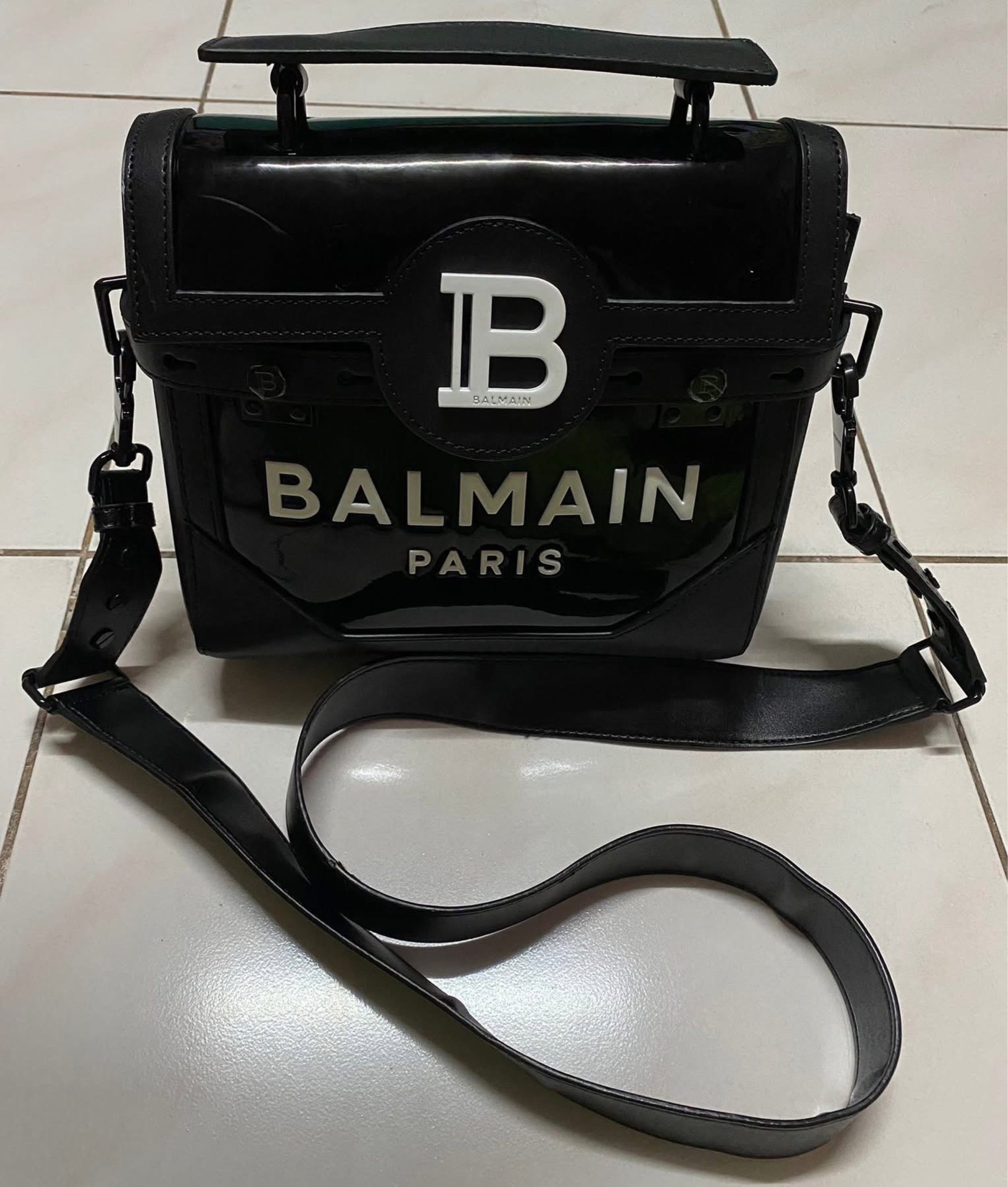 Balmain Paris 2-way top handle bag (Category: Luxury Bags & Wallets) located in Muntinlupa City. Submitted by prelovedbrandedgoodies (Listing ID 1419915846, Image 1). Description: - Balmain Paris handbag - Black color - Top handle - Detachable shoulder strap - Glossy finish - Balmain logo on front - Interior with Balmain logo and "Made in Italy" inscription.