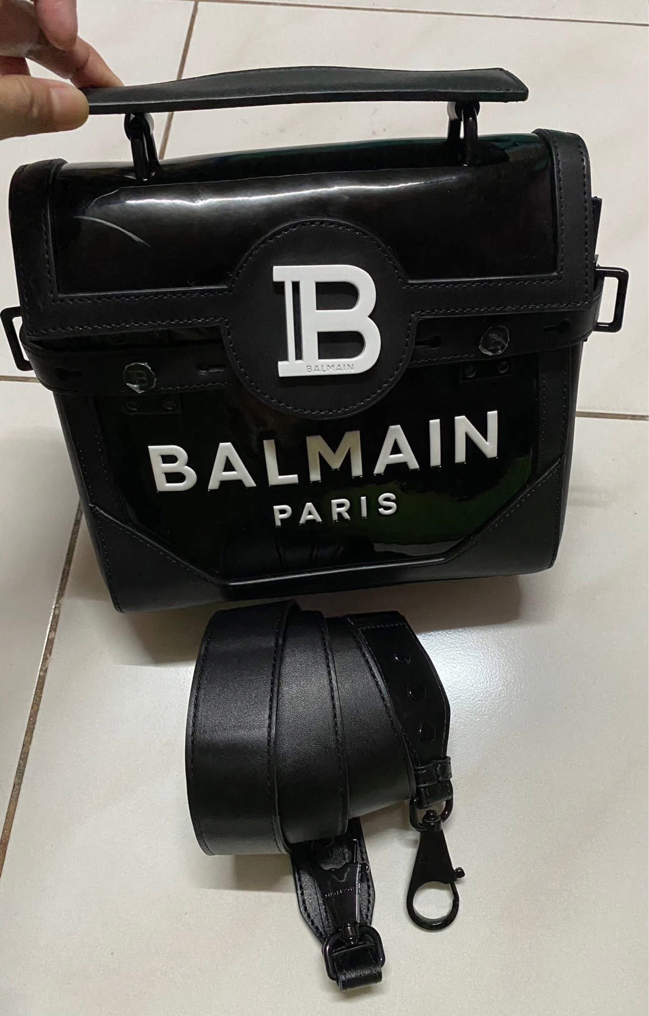 Balmain Paris 2-way top handle bag (Category: Luxury Bags & Wallets) located in Muntinlupa City. Submitted by prelovedbrandedgoodies (Listing ID 1419915846, Image 3). Description: - Balmain Paris handbag - Black color - Top handle - Detachable shoulder strap - Glossy finish - Balmain logo on front - Interior with Balmain logo and "Made in Italy" inscription.