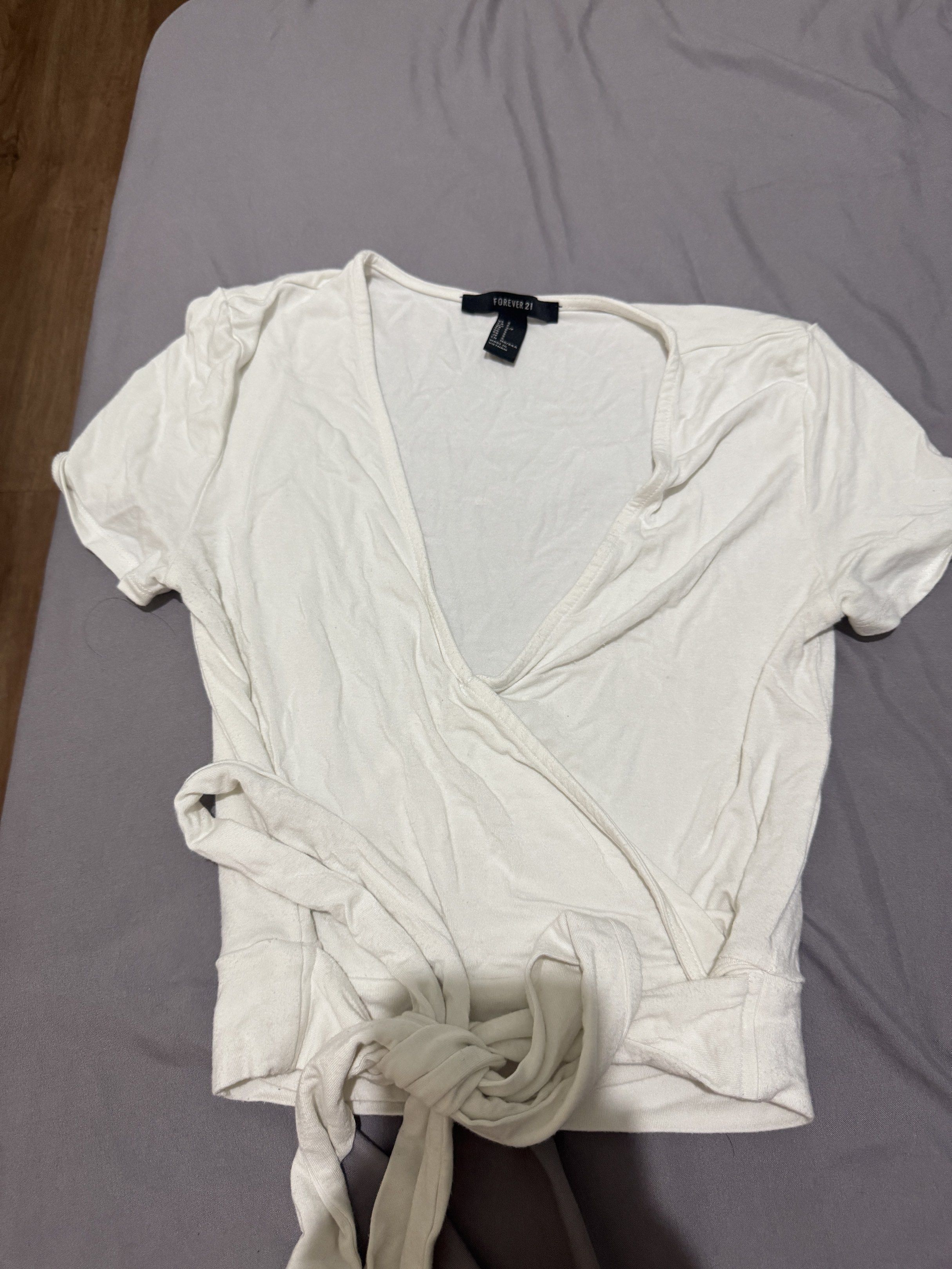 Forever 21 Wrap Top - White and Black (Category: Blouses) located in Pasig City. Submitted by caaex (Listing ID 1419940872, Image 2). Description: - Forever 21 wrap tops - Colors: White (Size S) and Black (Size M) - Features: V-neck, short sleeves - Made in Vietnam.