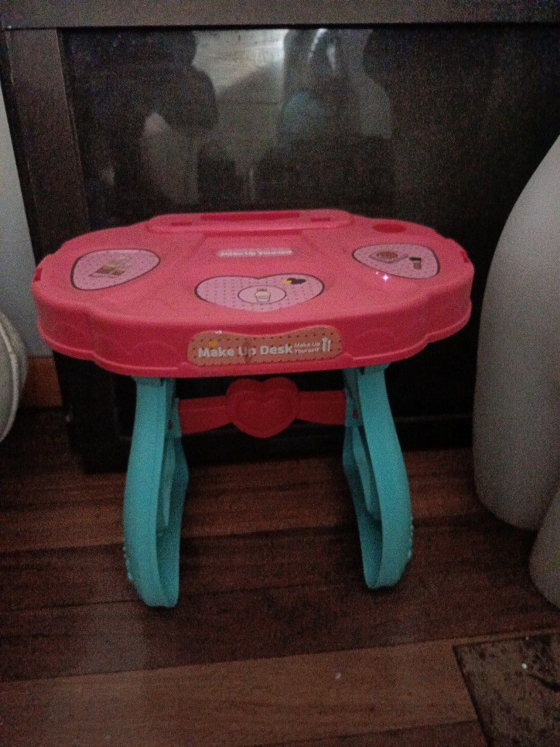 Kids' Makeup Desk with Chair (Category: Kids Tables & Chairs) located in Manila. Submitted by christcels78475 (Listing ID 1419812612, Image 2). Description: Kids' makeup desk comes with a matching chair. The desk is pink with a heart-shaped design and has a built-in mirror. The chair has a cartoon character on the seat. The desk has blue legs. It is a fun set for kids to play with..