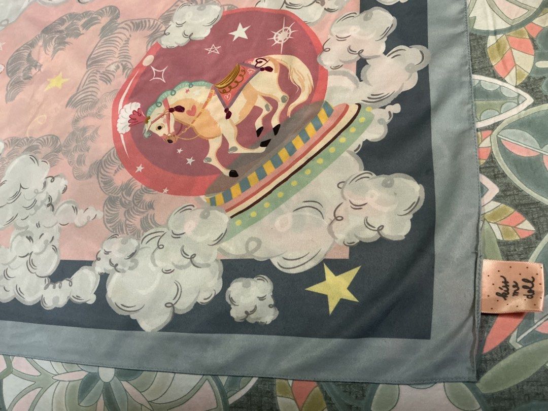Kiss Me Doll Carousel Scarf (Category: Scarves) located in Angeles City. Submitted by goodbuysathome (Listing ID 1419790387, Image 3). Description: - Carousel design scarf - Features horses, clouds, and stars - Pink background with blue border - Square shape - Brand tag visible - Perfect for adding a playful touch to your look -97x 103 cm soft silk from Japan Add sf 55 Gcash payment .