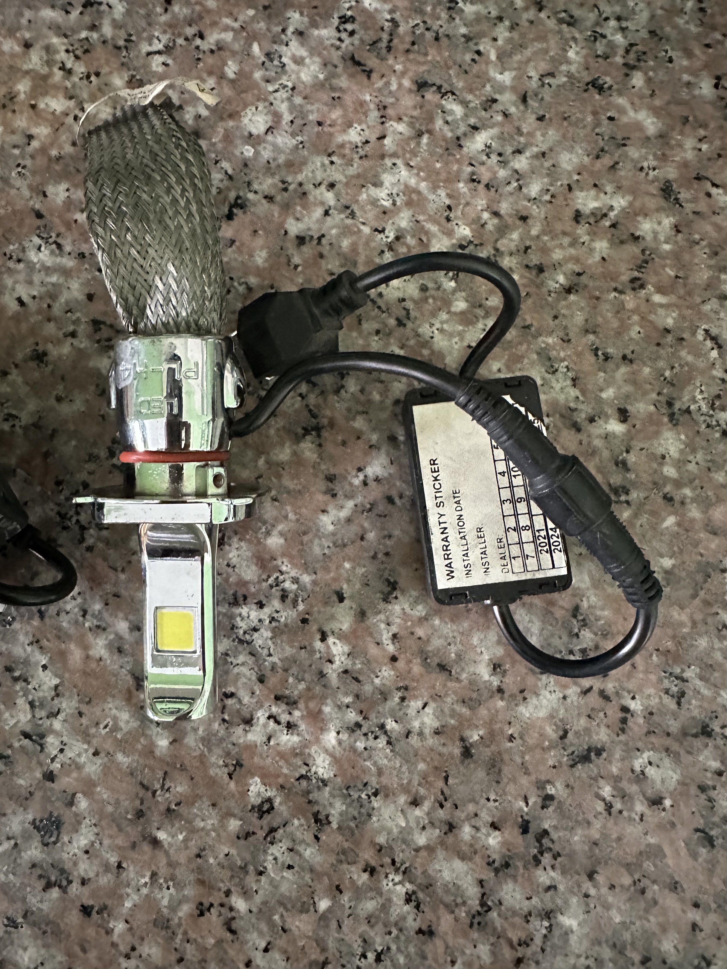 LED PL-H4 Headlight Bulbs (Category: Lightings, Horns, and other Electrical Parts and Accessories) located in Manila. Submitted by docards1102 (Listing ID 1419867255, Image 2). Description: - Pair of LED PL-H4 headlight bulbs - Silver finish - Braided heat dissipation cable - Includes warranty sticker - Warranty sticker shows installation dates.