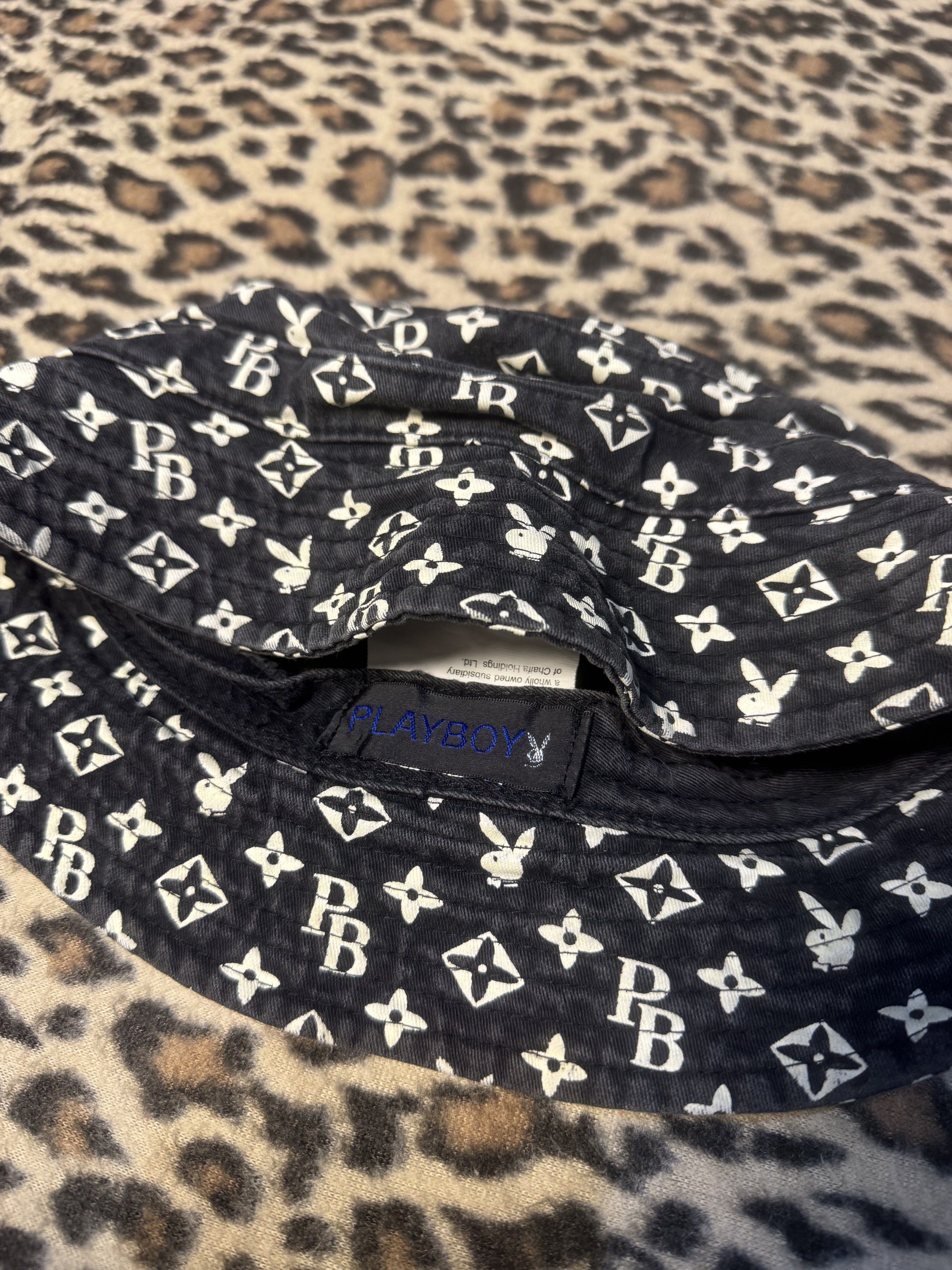 Louis Vuitton Playboy Bucket Hat (Category: Luxury Accessories) located in Kapangan. Submitted by keythsgs74798 (Listing ID 1419898561, Image 2). Description: - Playboy bucket hat - Color: Black with white logo pattern - Features the Playboy logo and "PB" initials - Licensed product from Chaifa Investment Ltd. - Made of soft fabric.